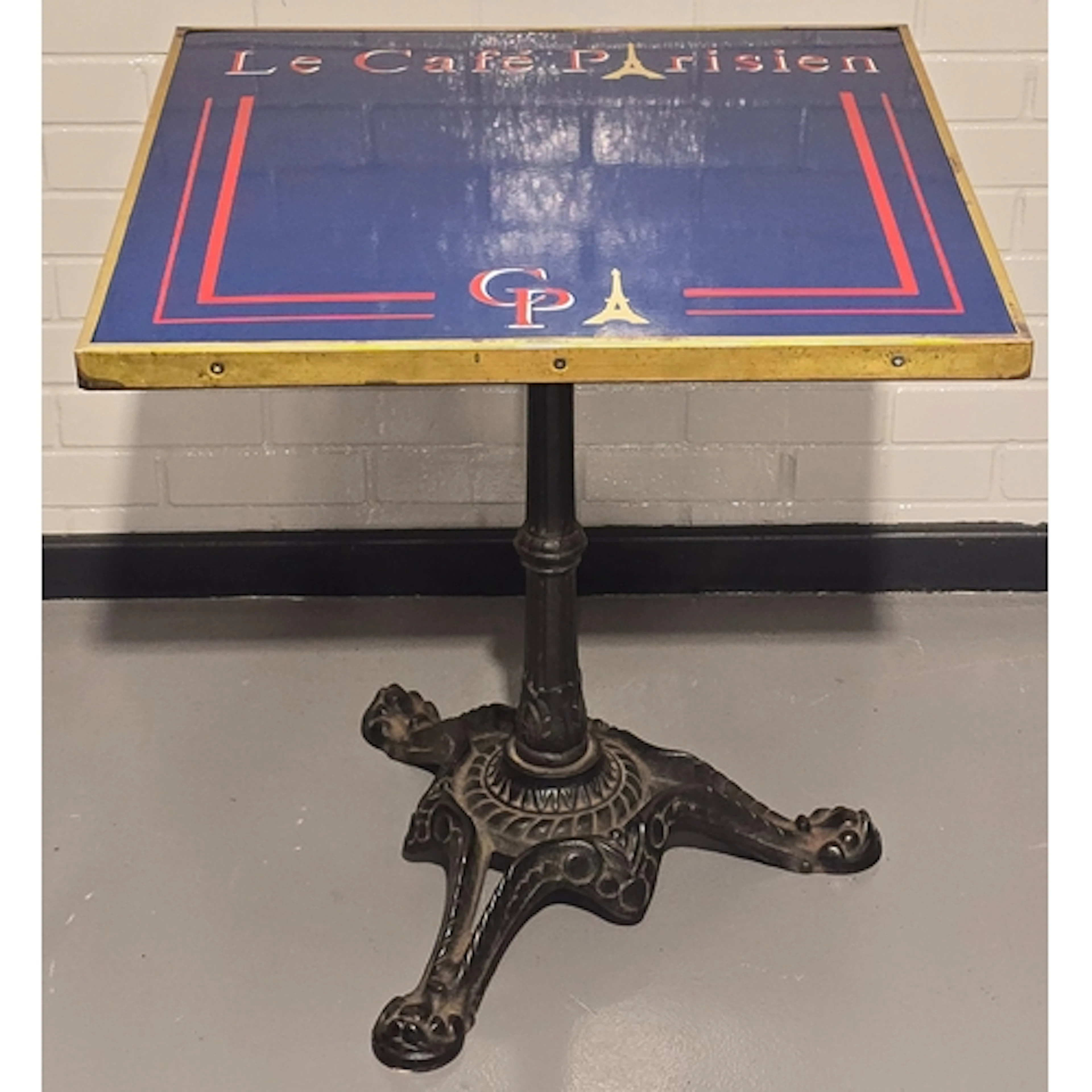 A vintage bistro table resting on heavy antique cast iron ba...