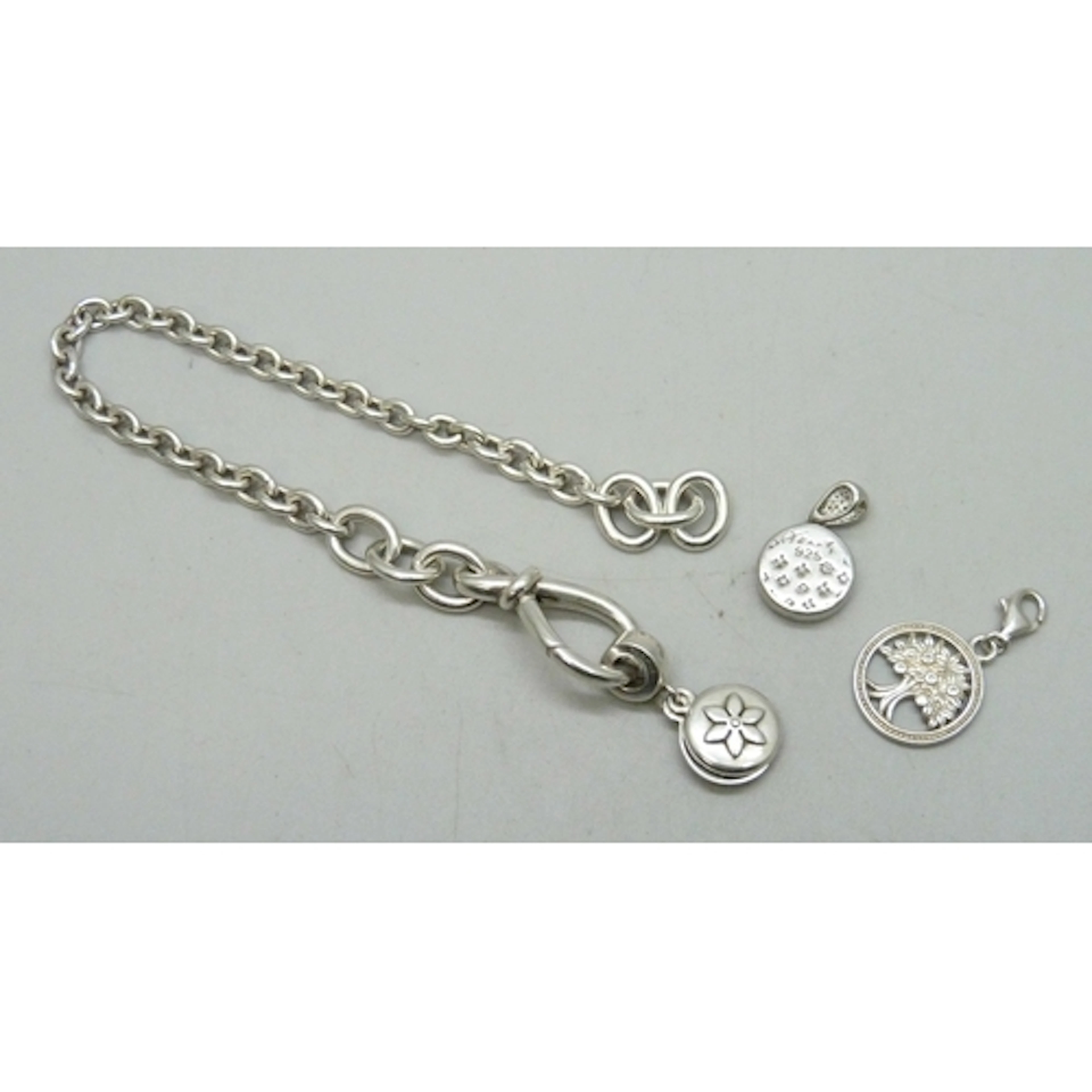 A Pandora silver bracelet with a Pandora charm, and two othe...