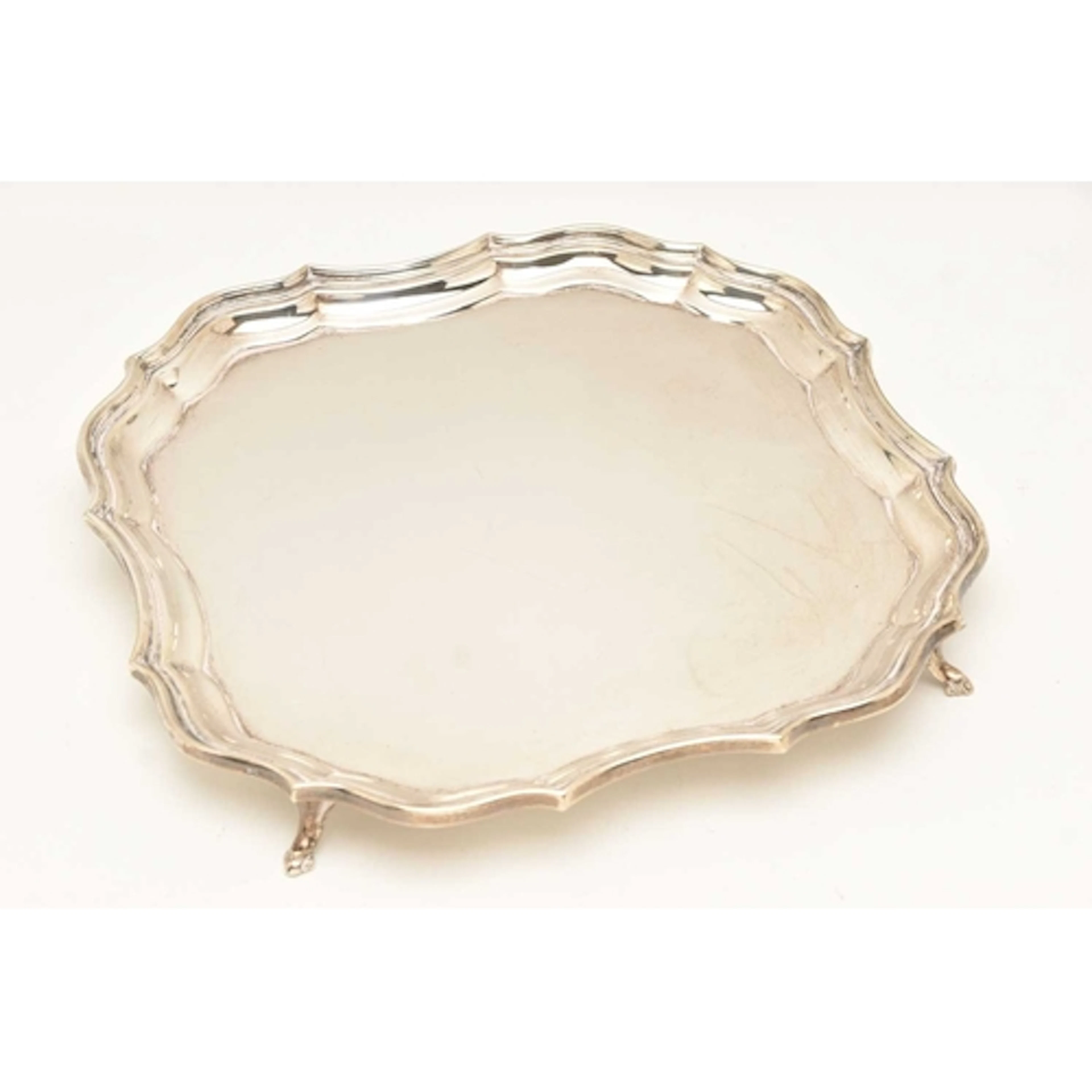 A GEORGE V SILVER FOOTED WAITER, of a wavy square form, rais...