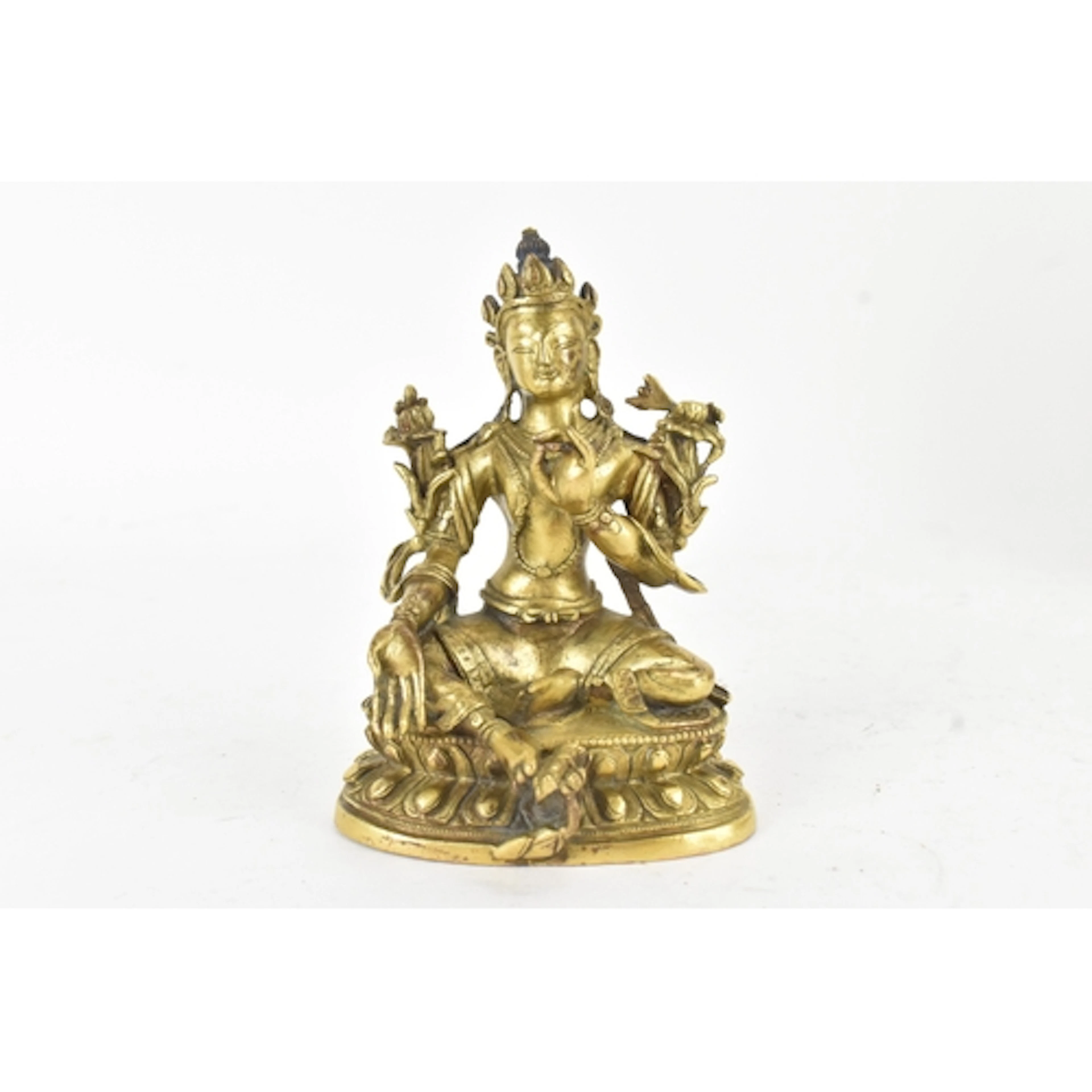 A Tibetan gilt-bronze figure of a four-armed bodhisattva, se...