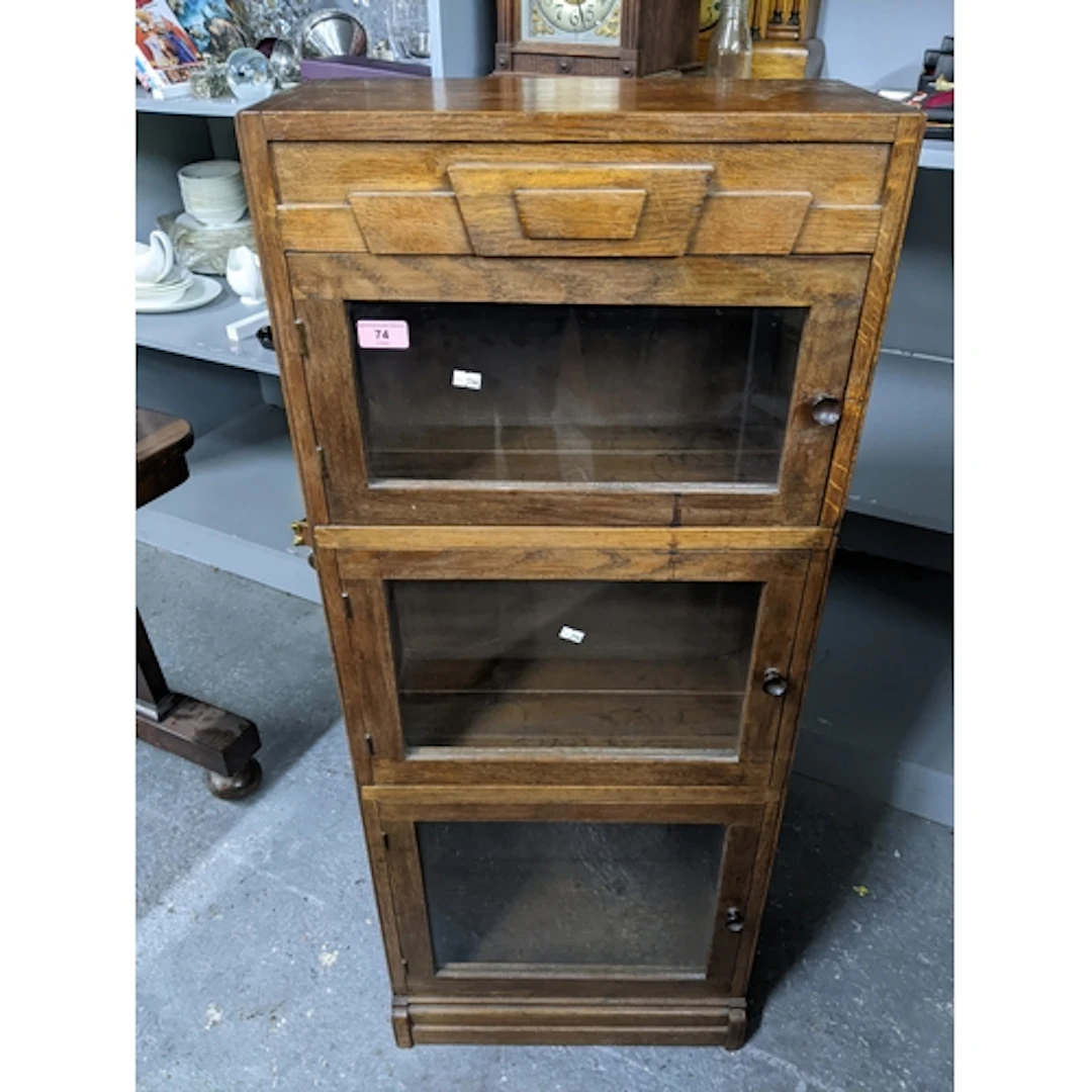 A 1930s oak three section style bookcase, three glazed doors...