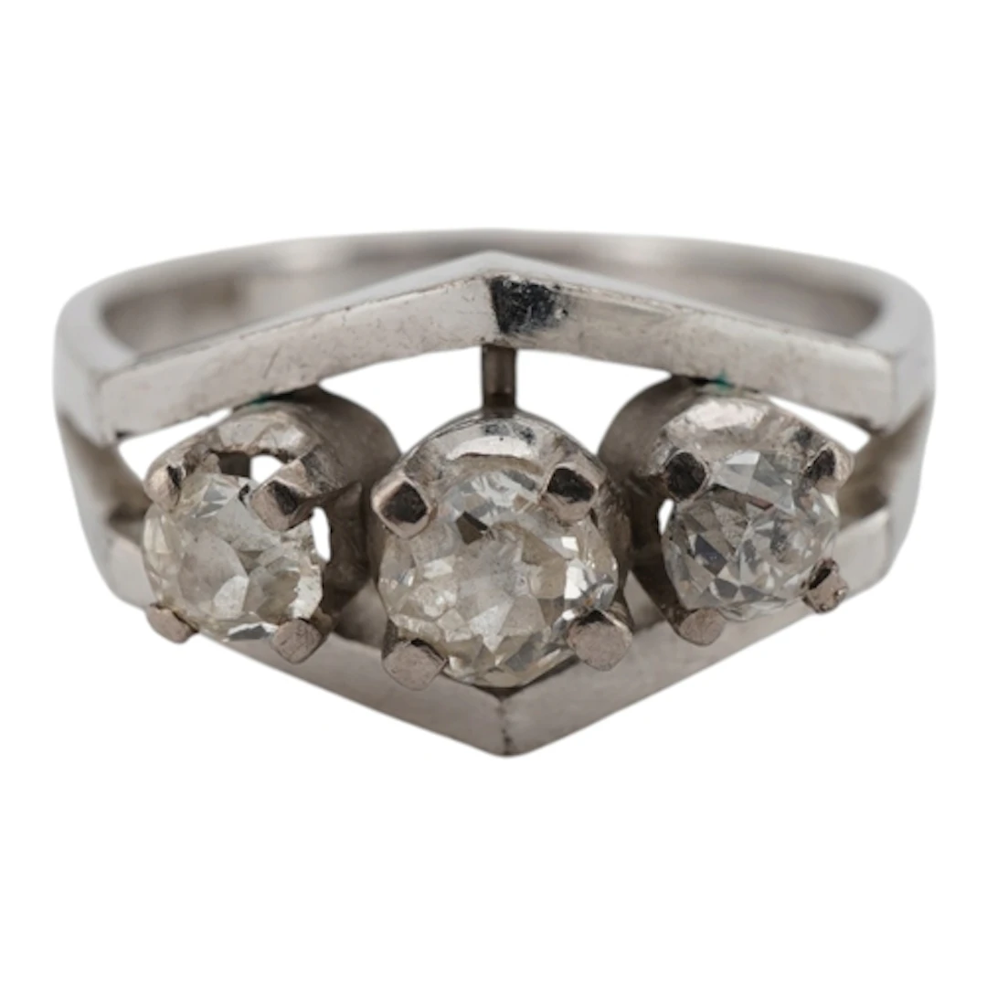 A white metal and three stone diamond set ring, the central ...