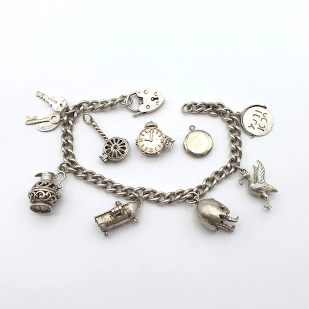A vintage silver Charm Bracelet with a quantity of charms at...