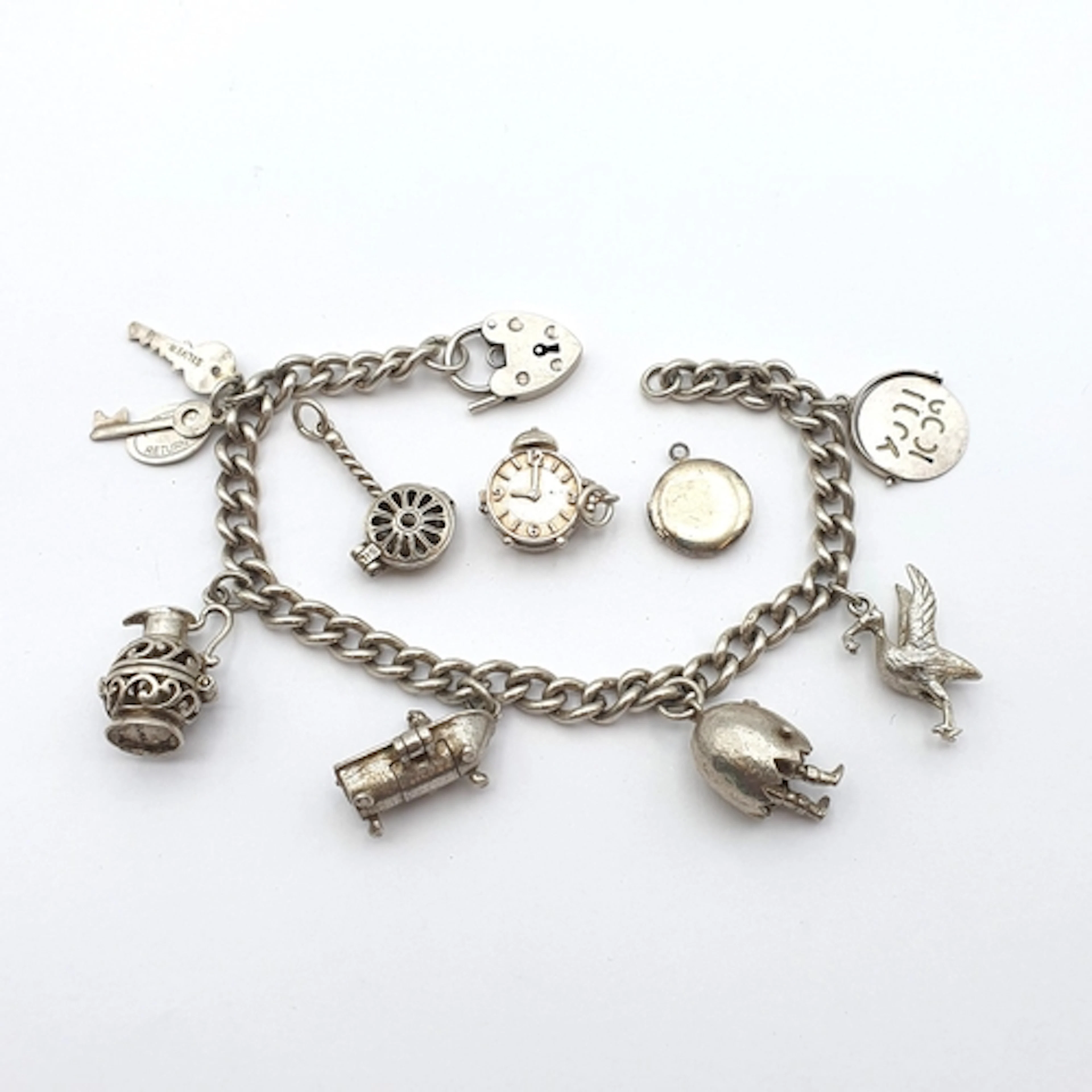 A vintage silver Charm Bracelet with a quantity of charms at...