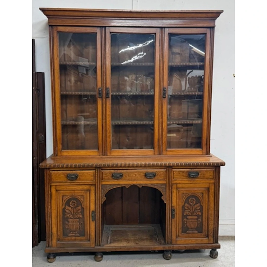A carved oak dresser with three glazed drawers over three dr...