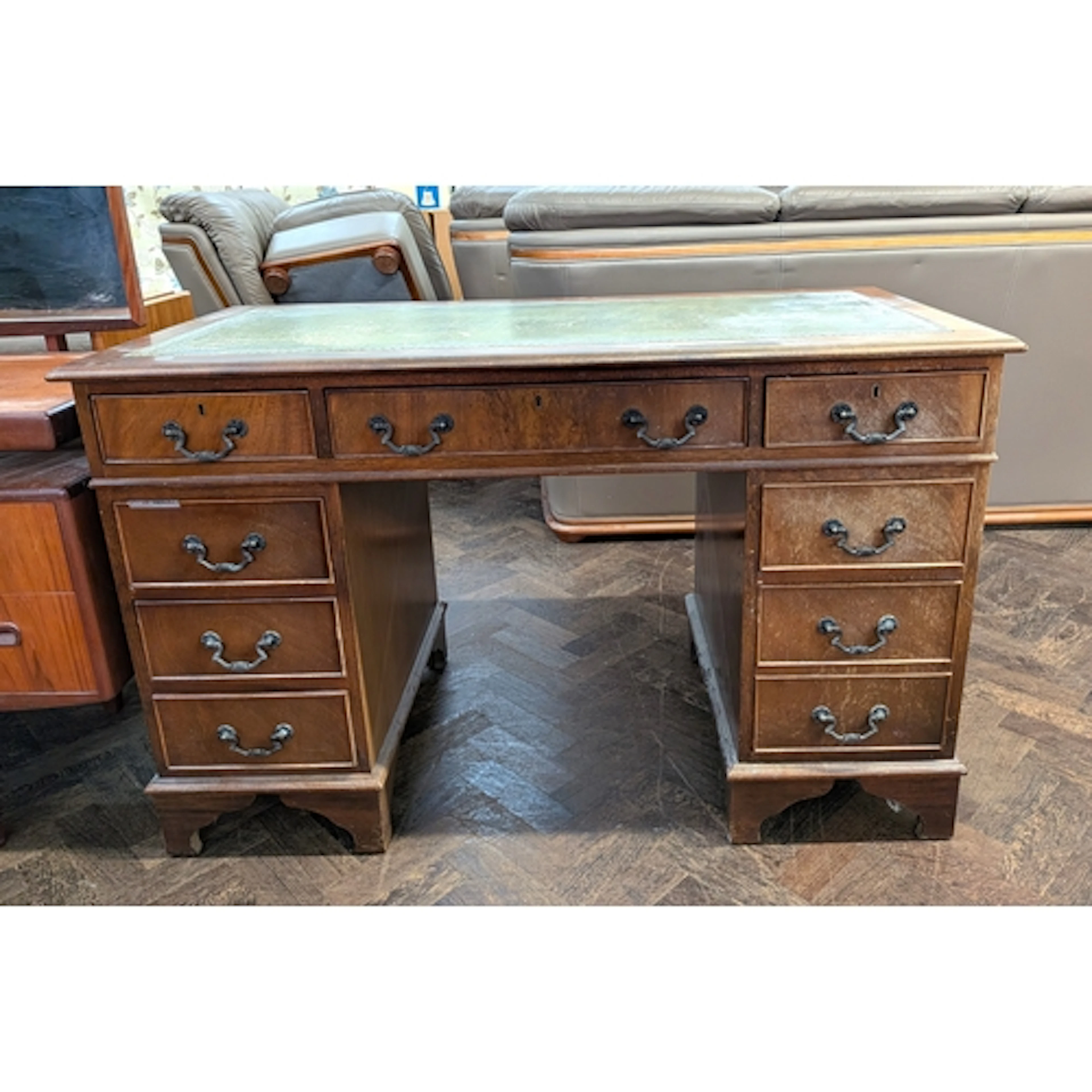 An Edwardian mahogany kneehole pedestal desk fitted nine dra...