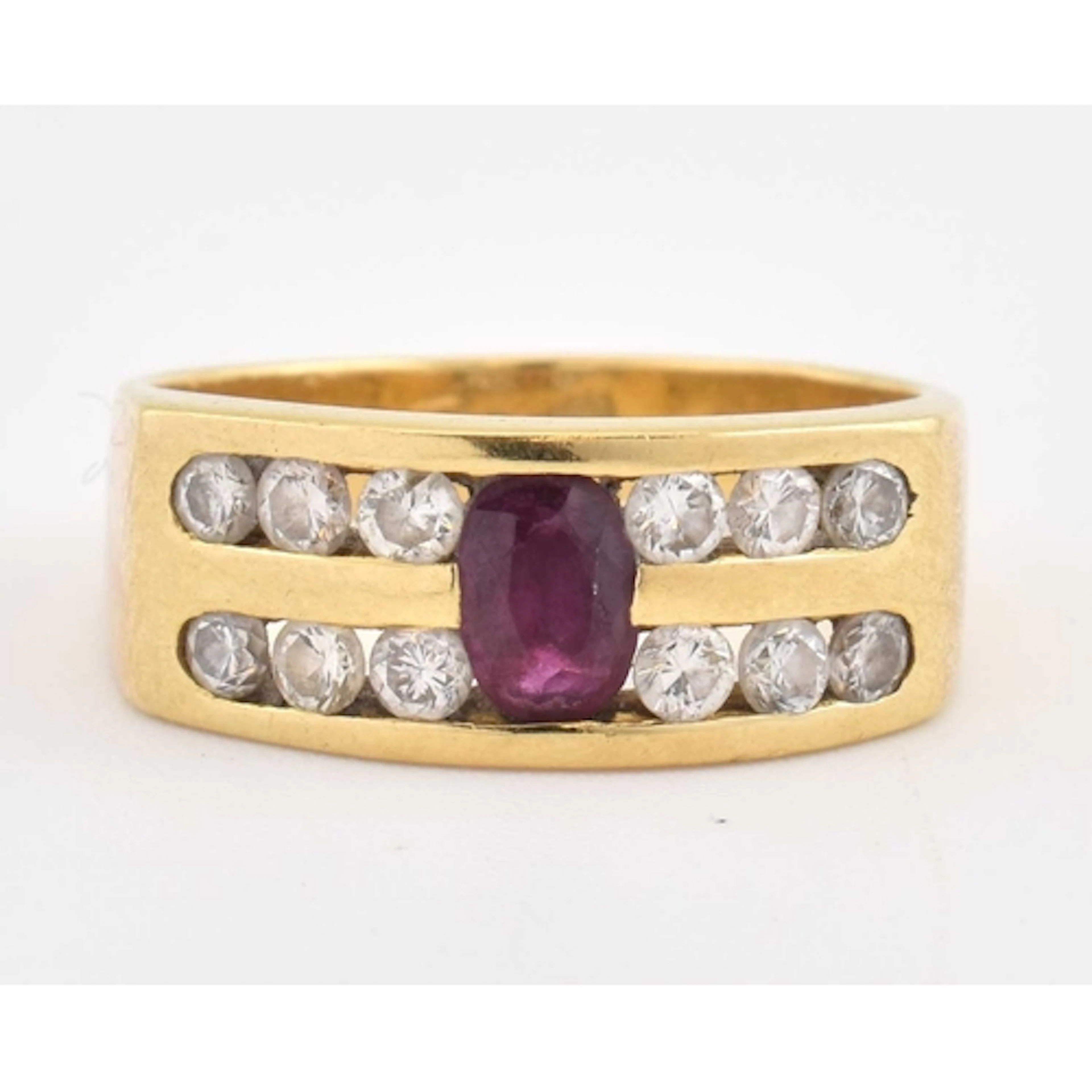 An 18ct gold ruby and diamond ring. Set with an oval ruby, f...