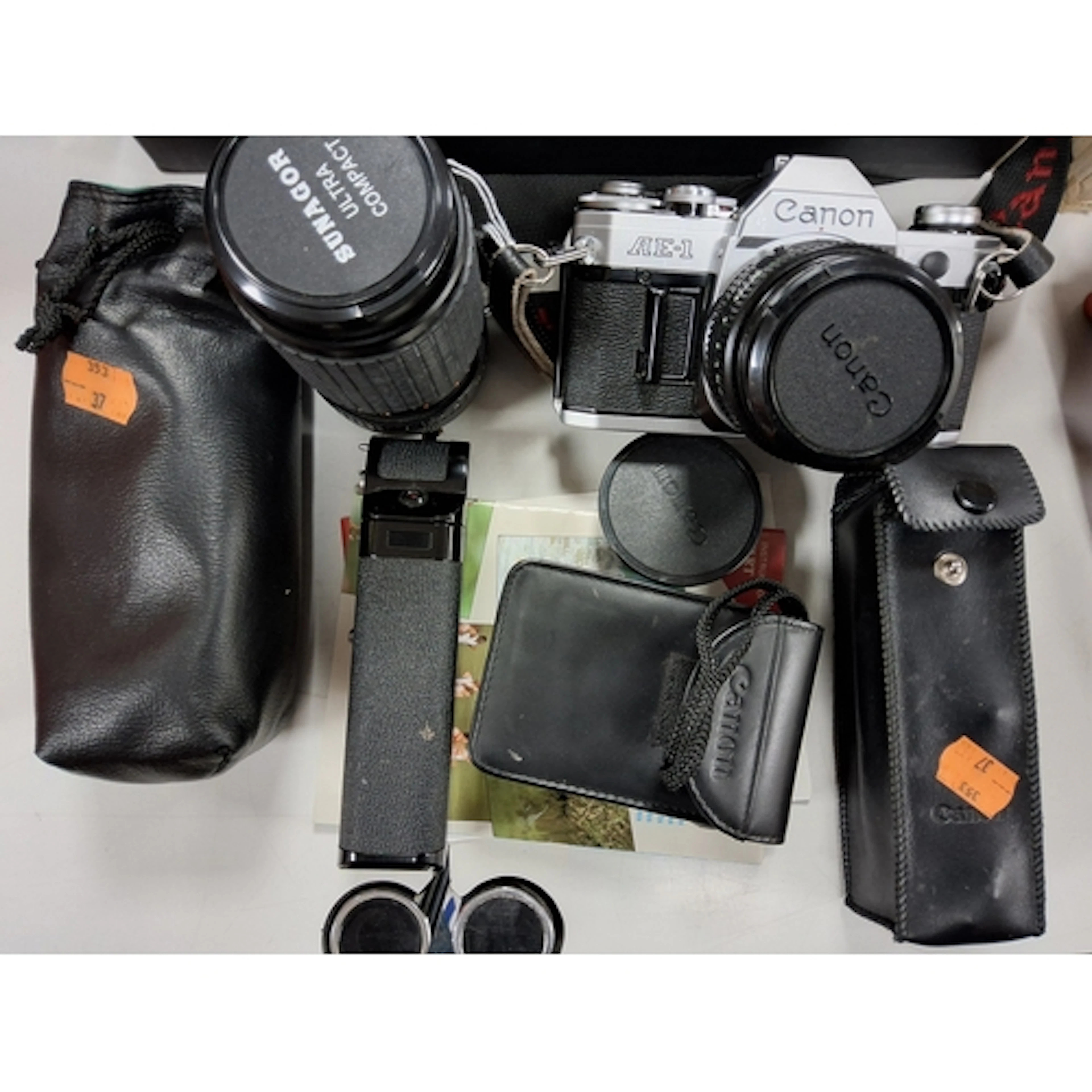 A CANON AE-1 CAMERA AND SUNAGOR LENS comprising a Canon AE-1...