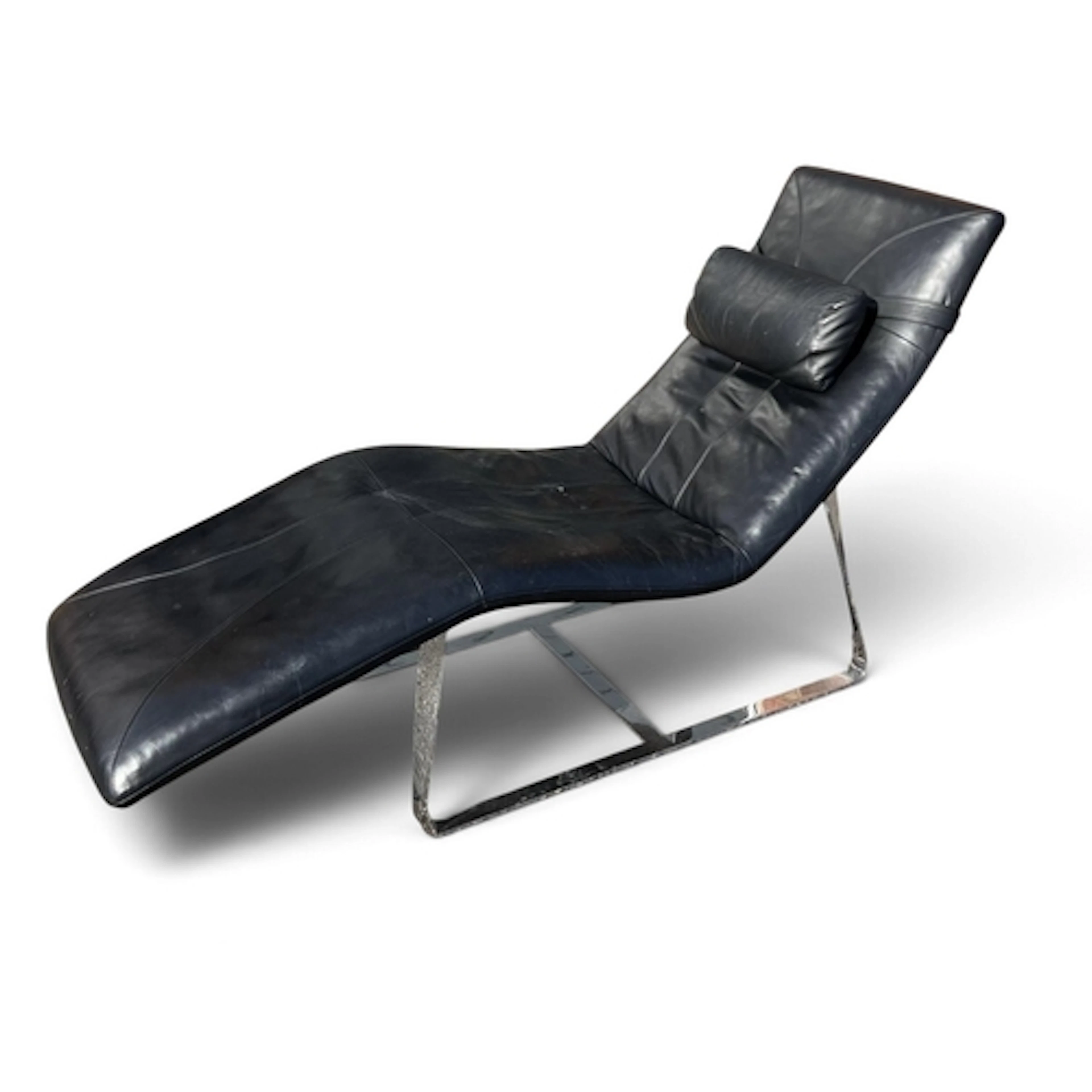 A MID-CENTURY BLACK LEATHER AND CHROME CHAISE LONGUE BY ROLF...