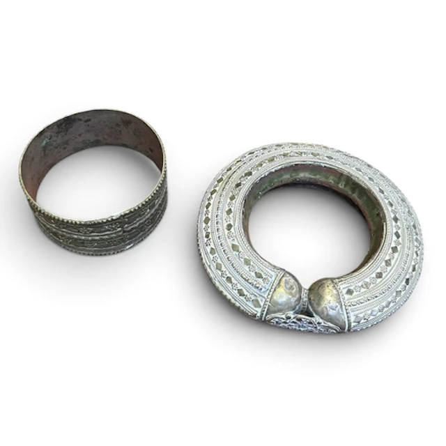 A SILVER TRIBAL BANGLE AND ANOTHER METAL BANGLE Largest 13cm...