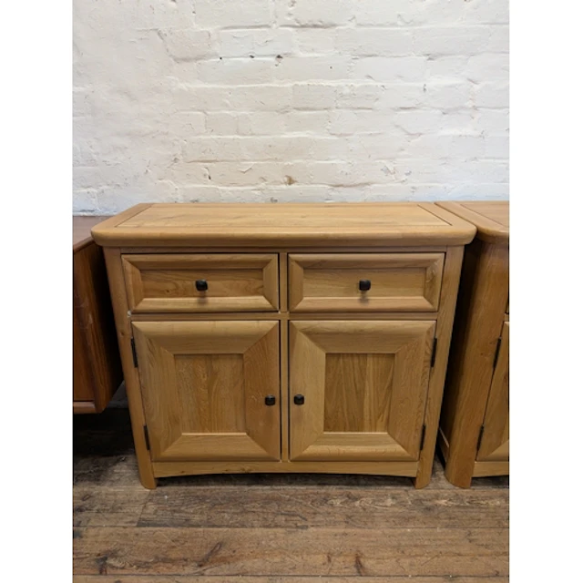 A small light oak sideboard fitted two drawers and cupboards...