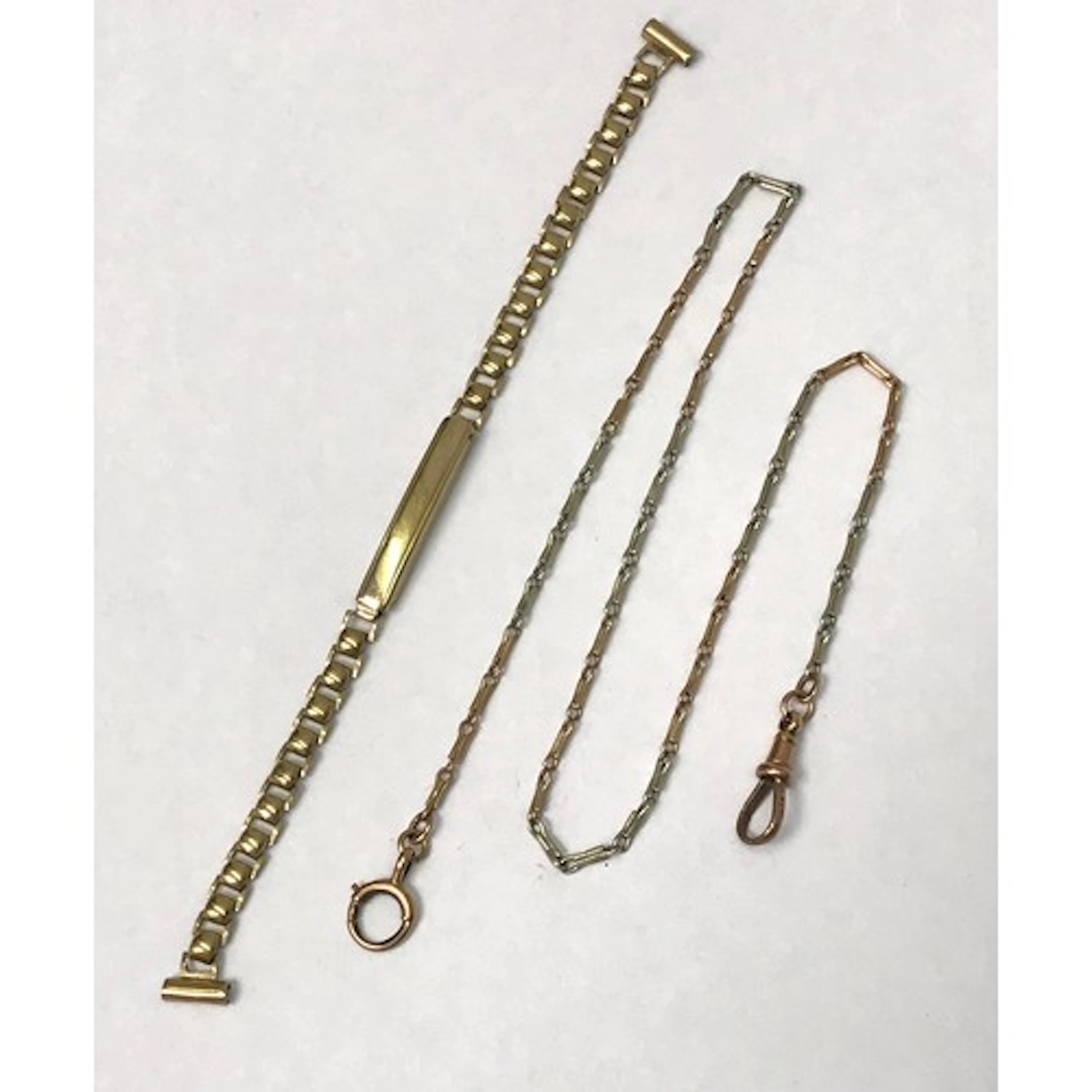 A slim single length watch chain, yellow metal, the ends ind...
