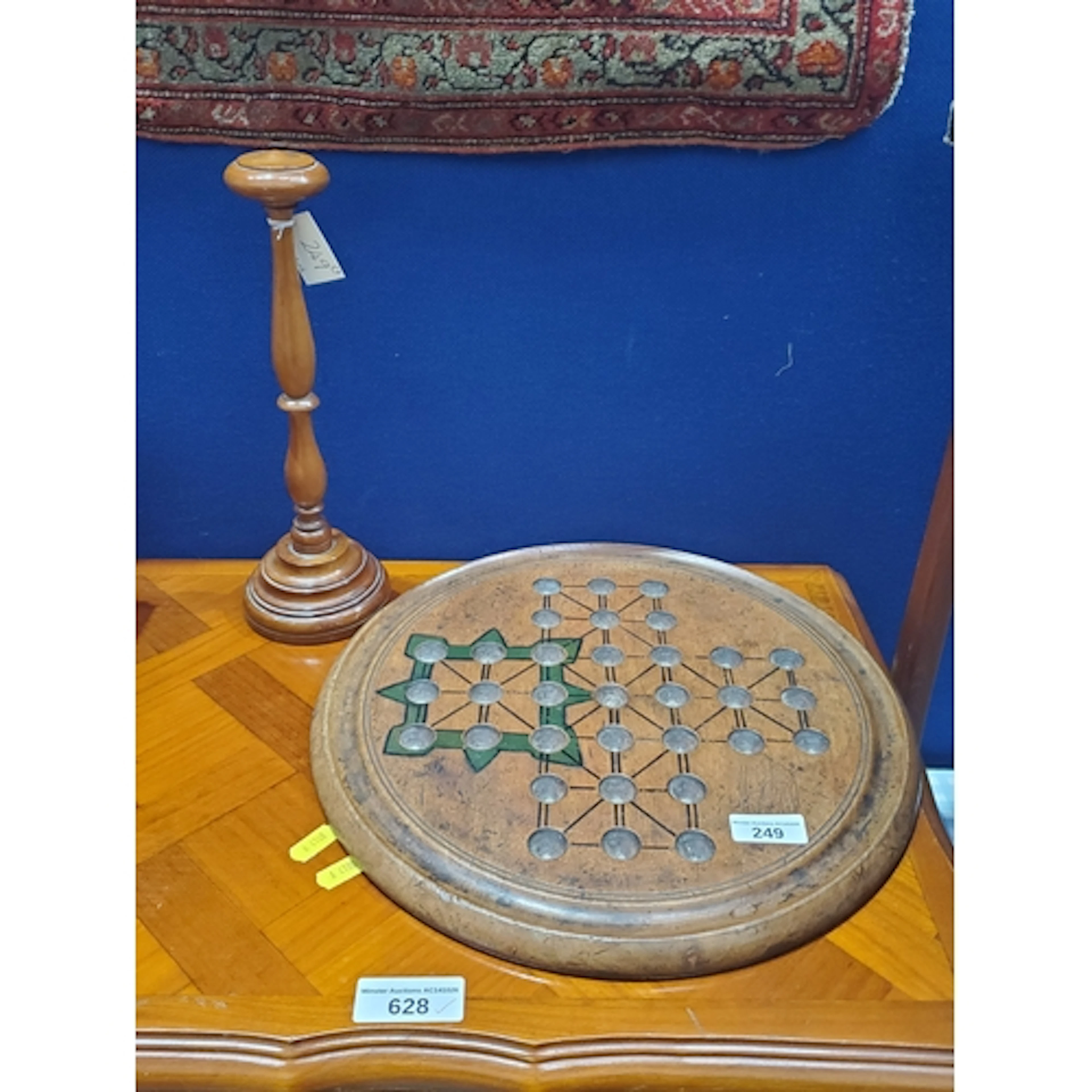 A turned wooden Solitaire Board, with game description on re...