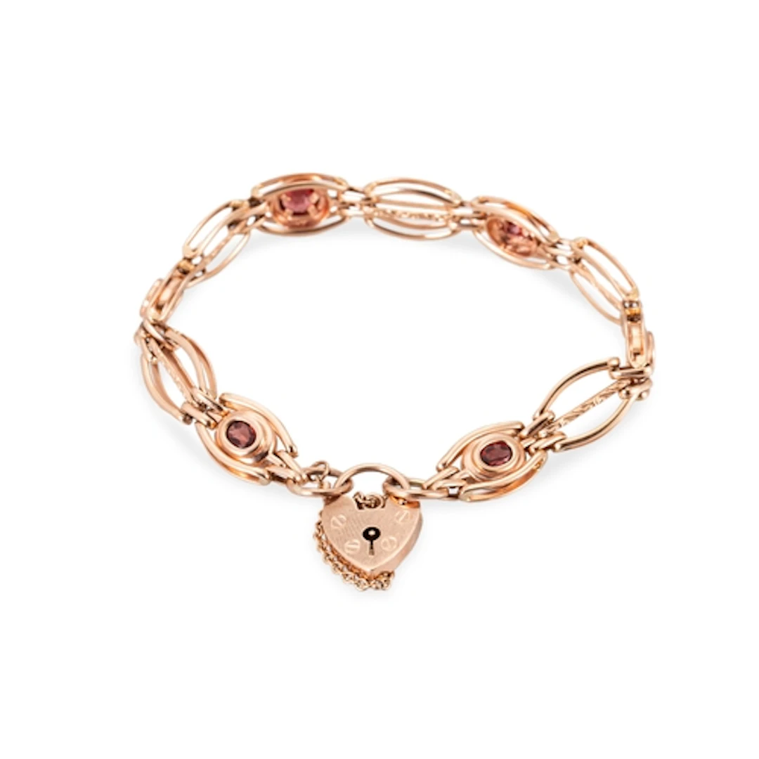 A 9CT ROSE GOLD GARNET SET BRACELET, with padlock clasp, 15....