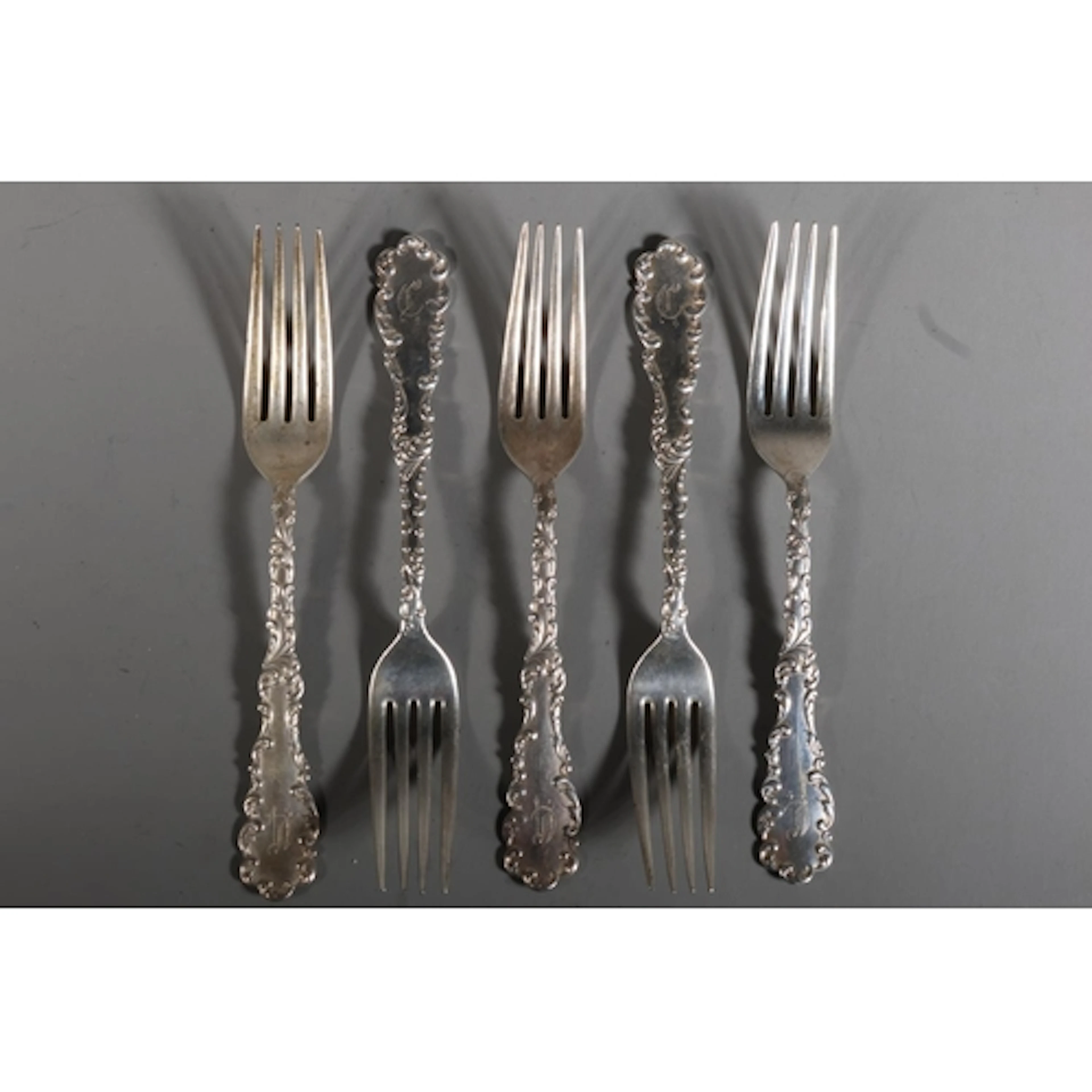 Set of five American silver fancy pattern dessert forks with...