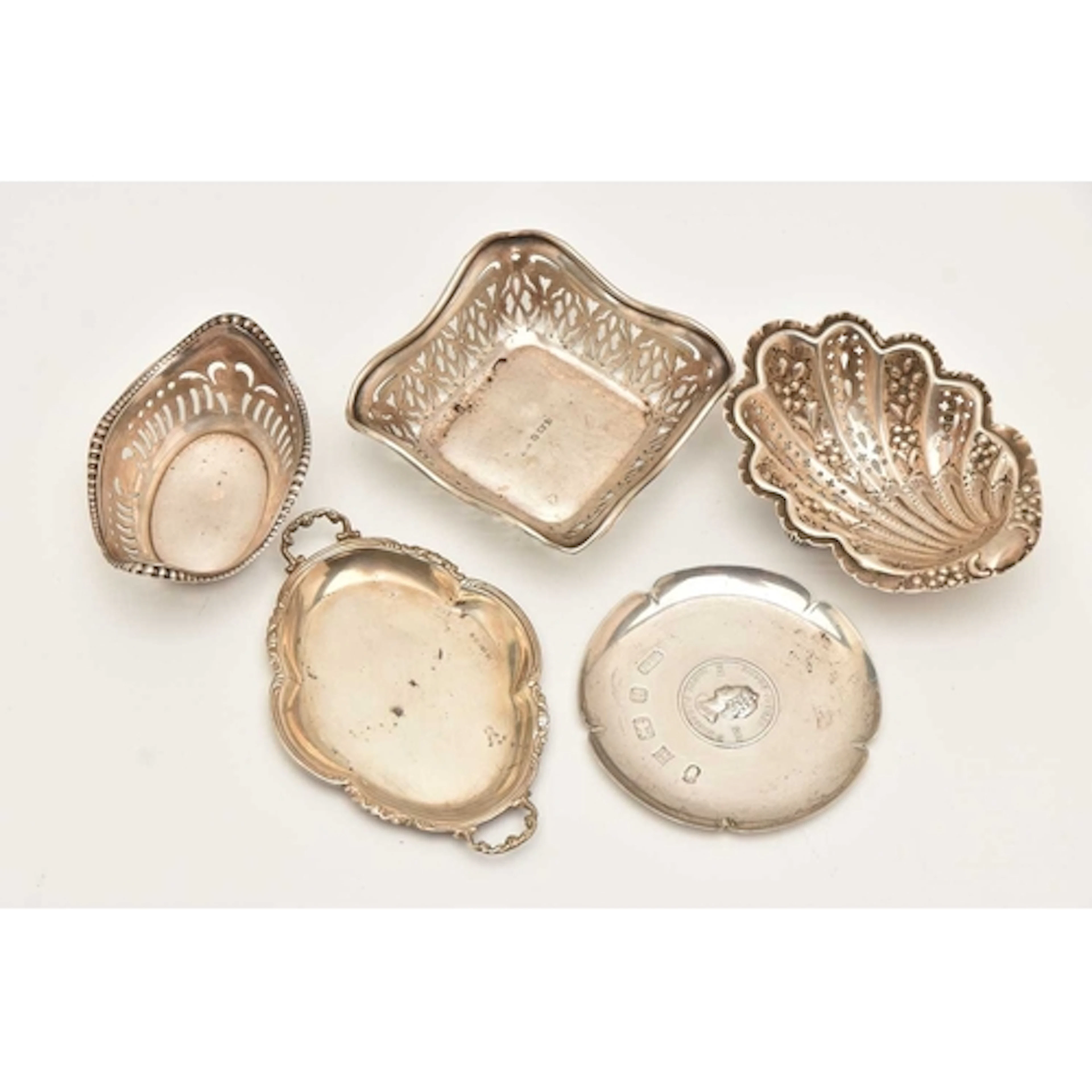 THREE SILVER BONBON DISHES AND TWO SMALL TRAYS, various desi...