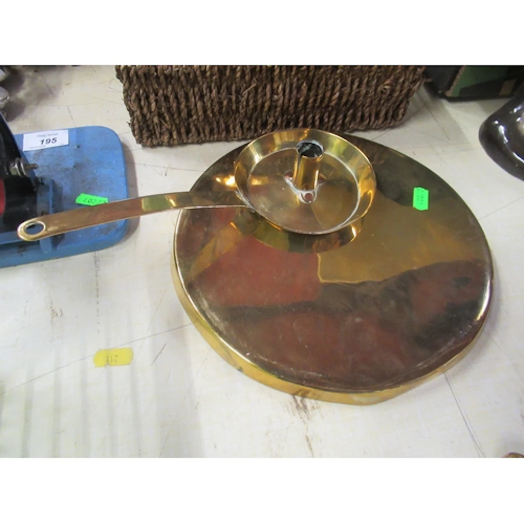 A brass chamberstick, together with a brass circular cover
