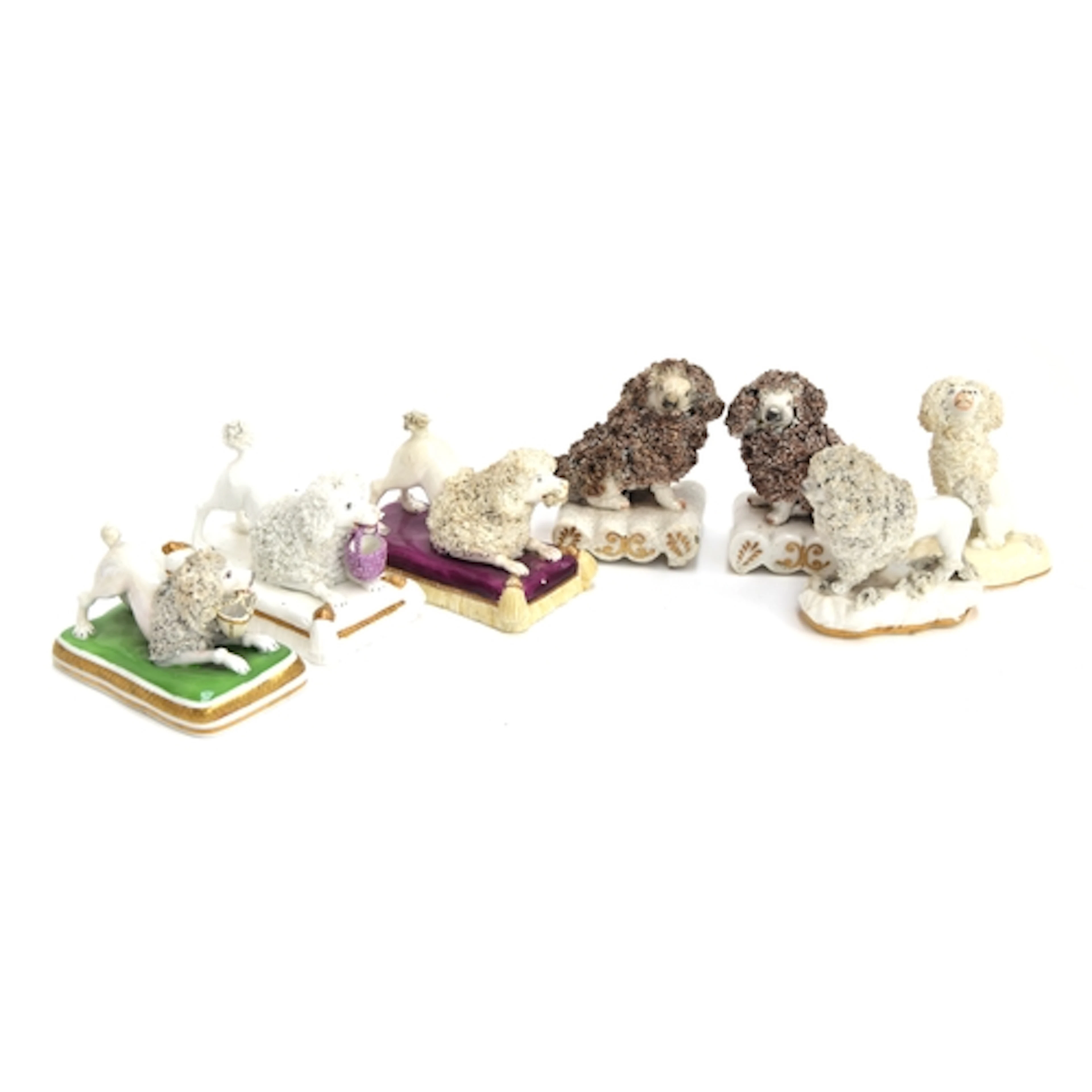 A collection of eight 19th century porcelain poodle figures,...