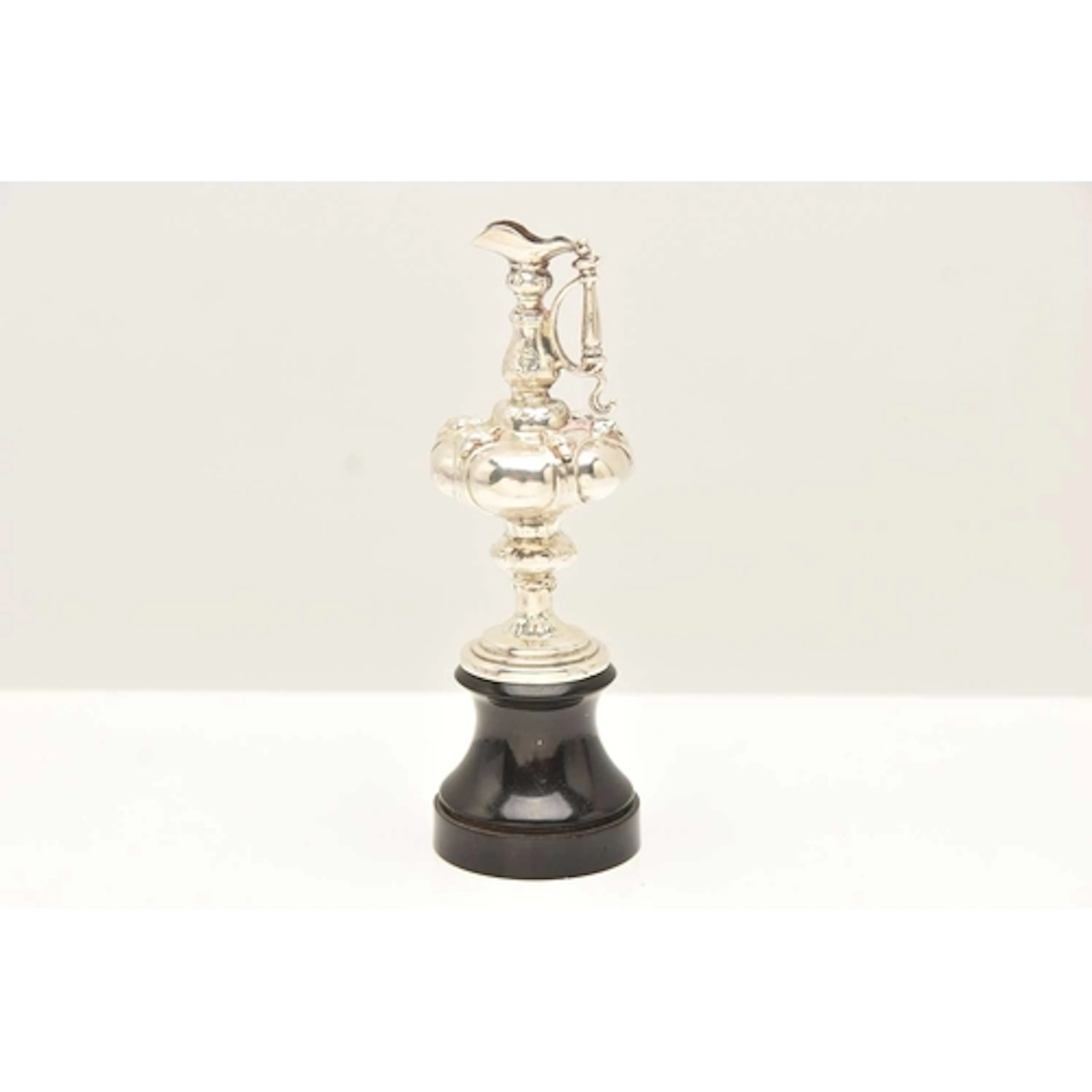A WHITE METAL MINIATURE JUG WITH PLINTH, stamped 'Sterling',...