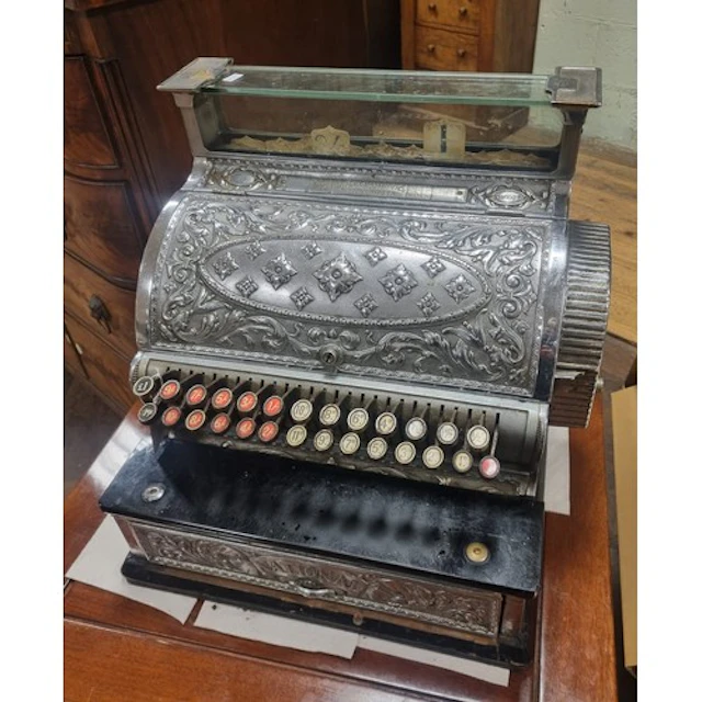 An antique National cash register within a nickel or chrome ...