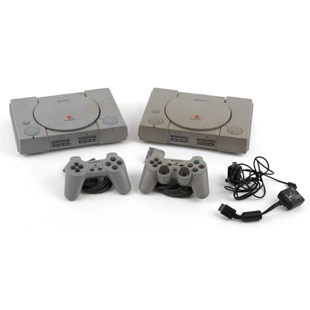 Two Sony PlayStation games consoles with two controllers.
