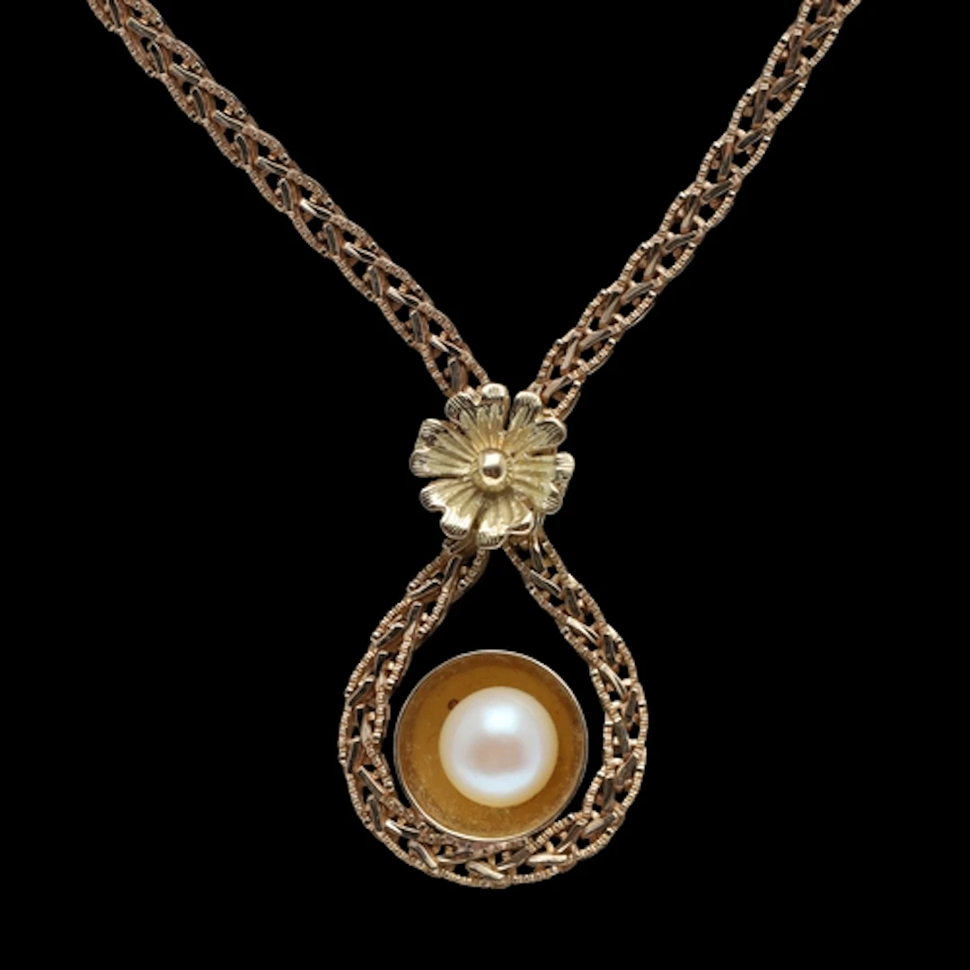 AN 18CT GOLD AND CULTURED PEARL NECKLACE. the central cultur...