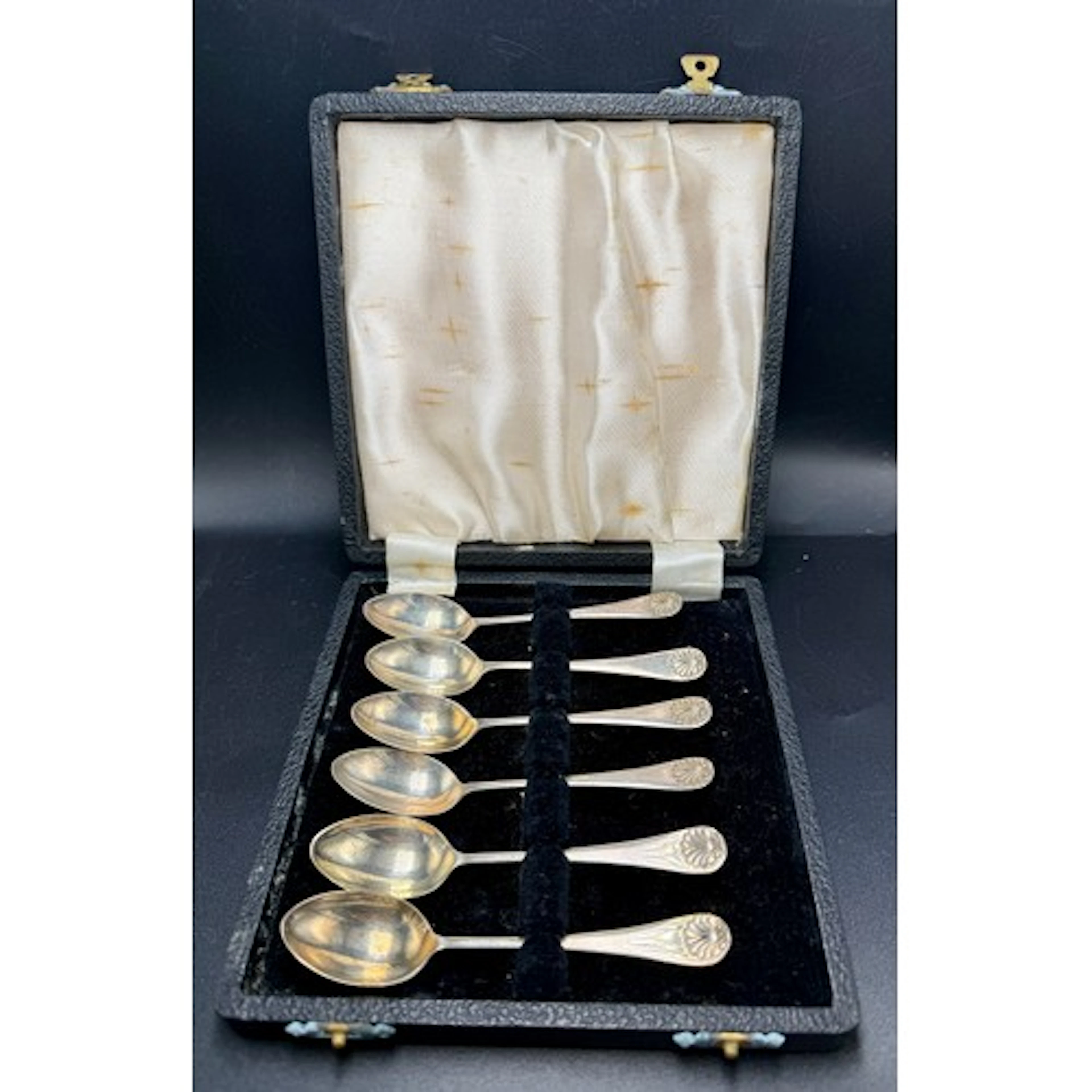 Set of six cased silver coffee spoons with shell finials. Bi...