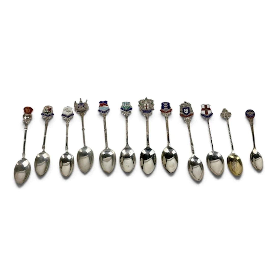 A COLLECTION OF TWELVE SILVER SOUVENIR SPOONS, TEN WITH ENAM...