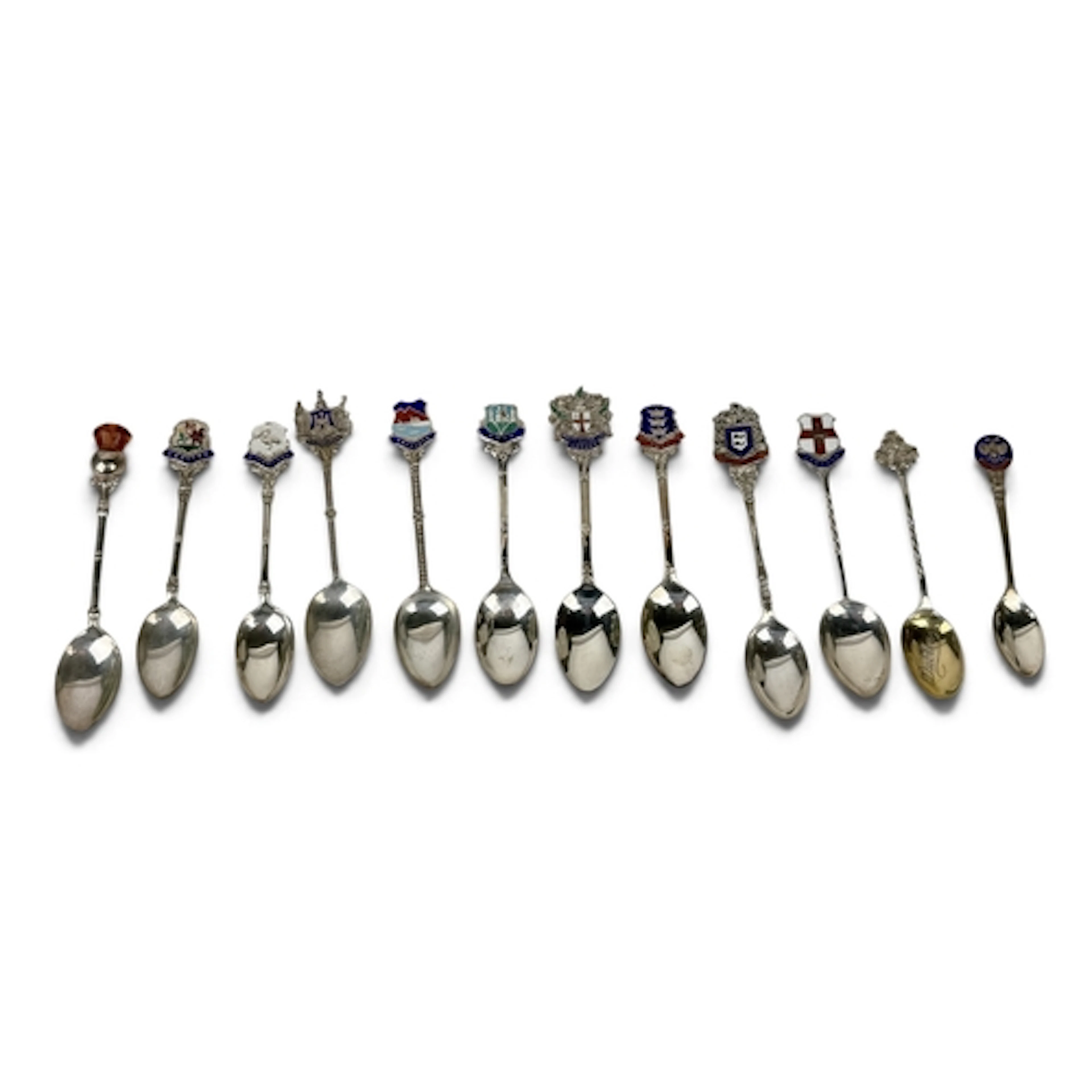 A COLLECTION OF TWELVE SILVER SOUVENIR SPOONS, TEN WITH ENAM...
