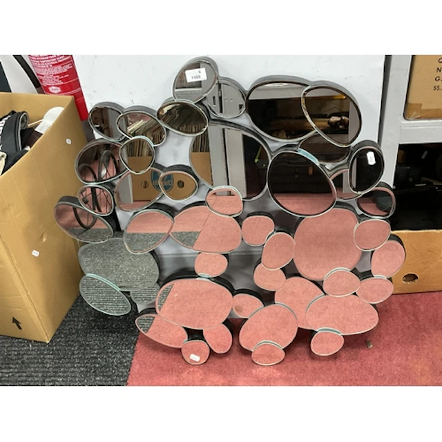 A large pebble-design wall mirror, featuring multiple cluste...