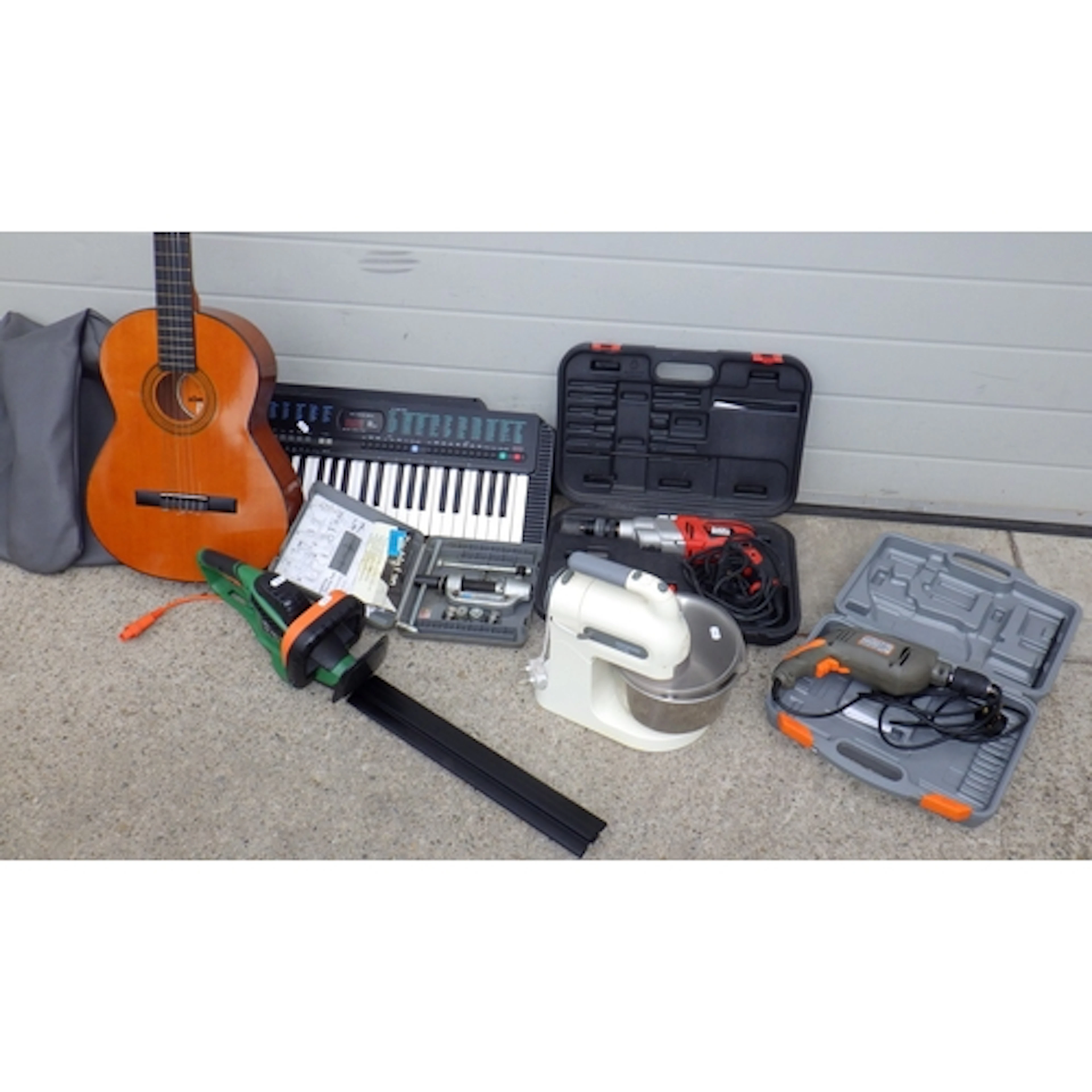 A guitar, keyboard, tools, hedge cutter, food mixer