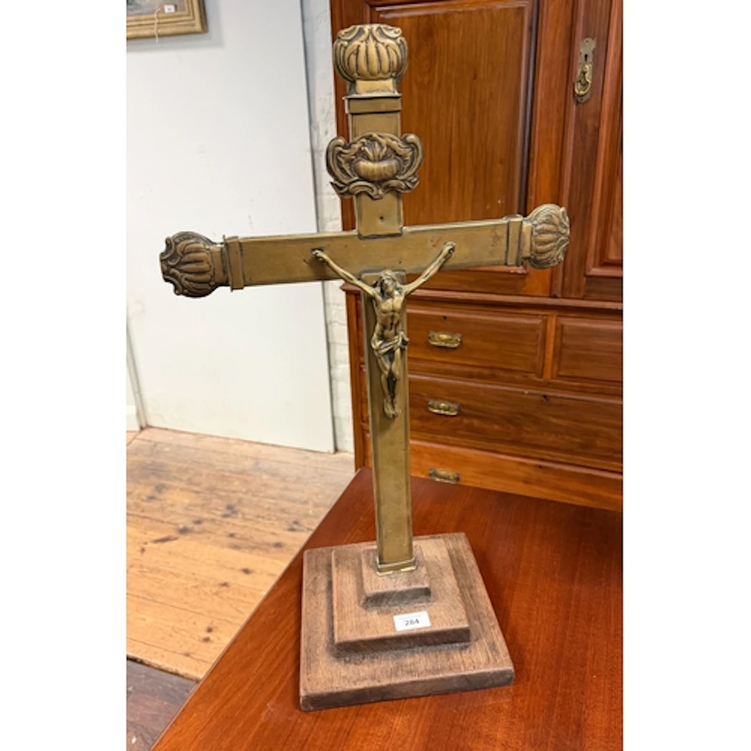 A large brass crucifix on an oak base, 25 1/2" tall