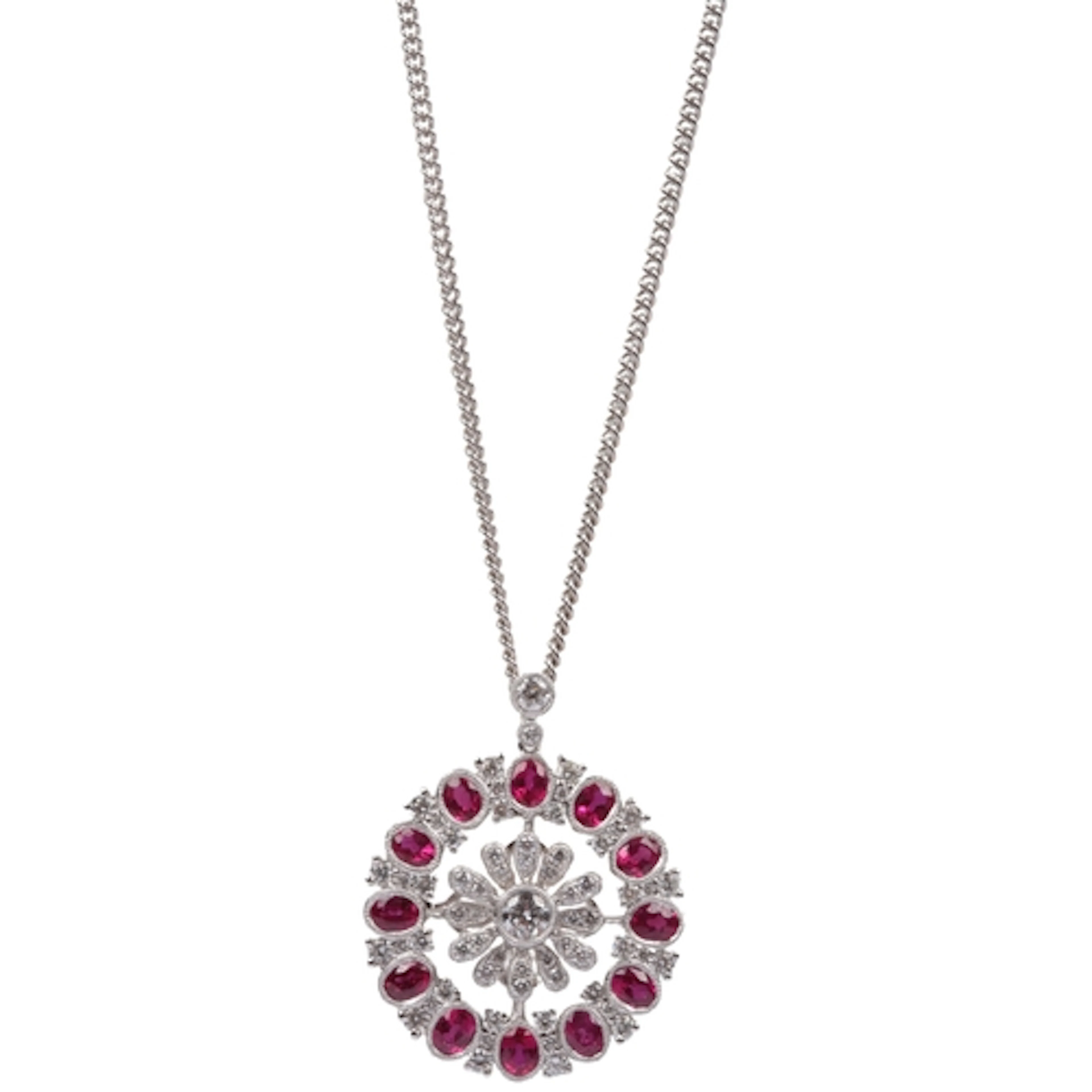 A ruby and diamond pendant, designed as a floral medallion s...