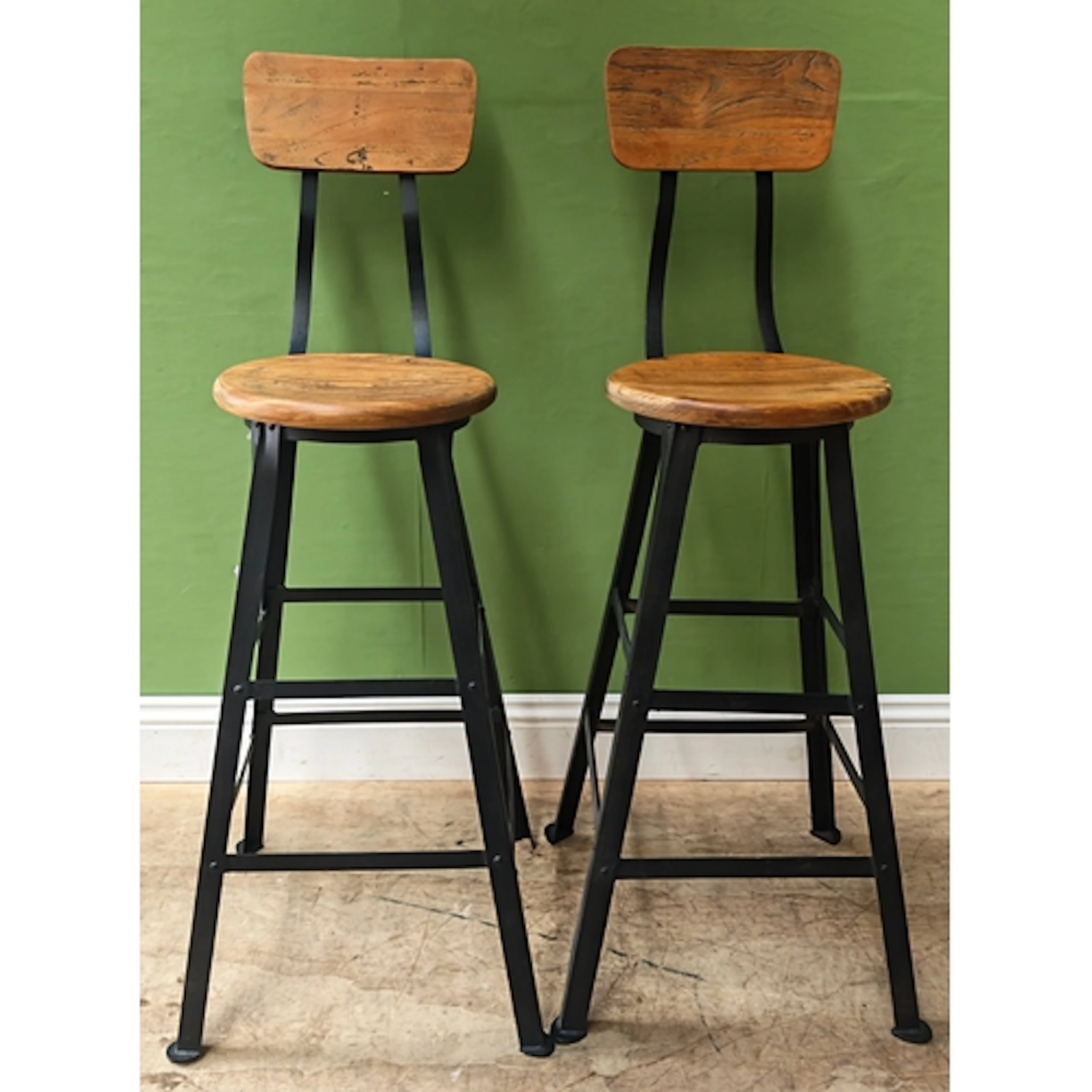 A pair of modern kitchen highchairs on fabricated metal base...