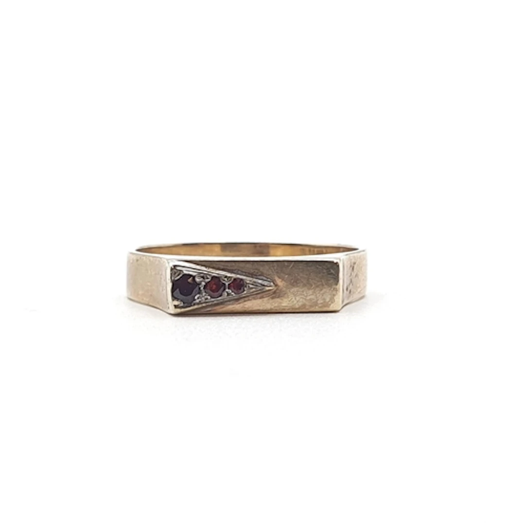 A modernist 9ct gold Ring set three graduated round garnets,...