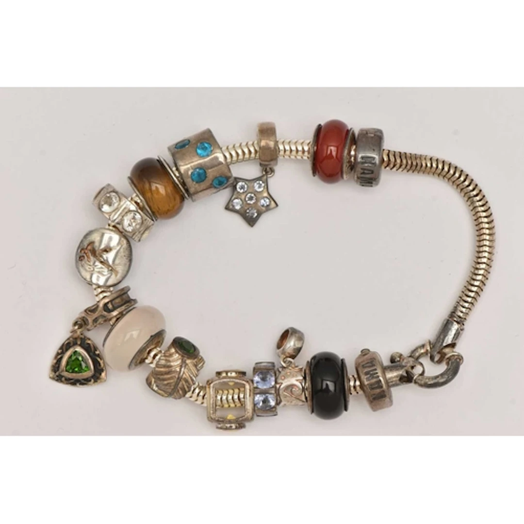 A SILVER CHARM BRACELET, snake bracelet fitted with a large ...