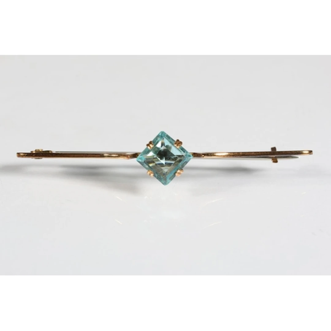 9ct gold bar brooch set with aquamarine coloured pale blue s...