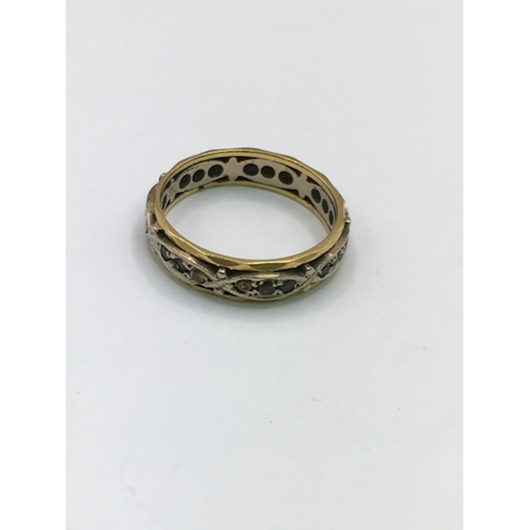 An unmarked yellow and white gold band ring set with small b...