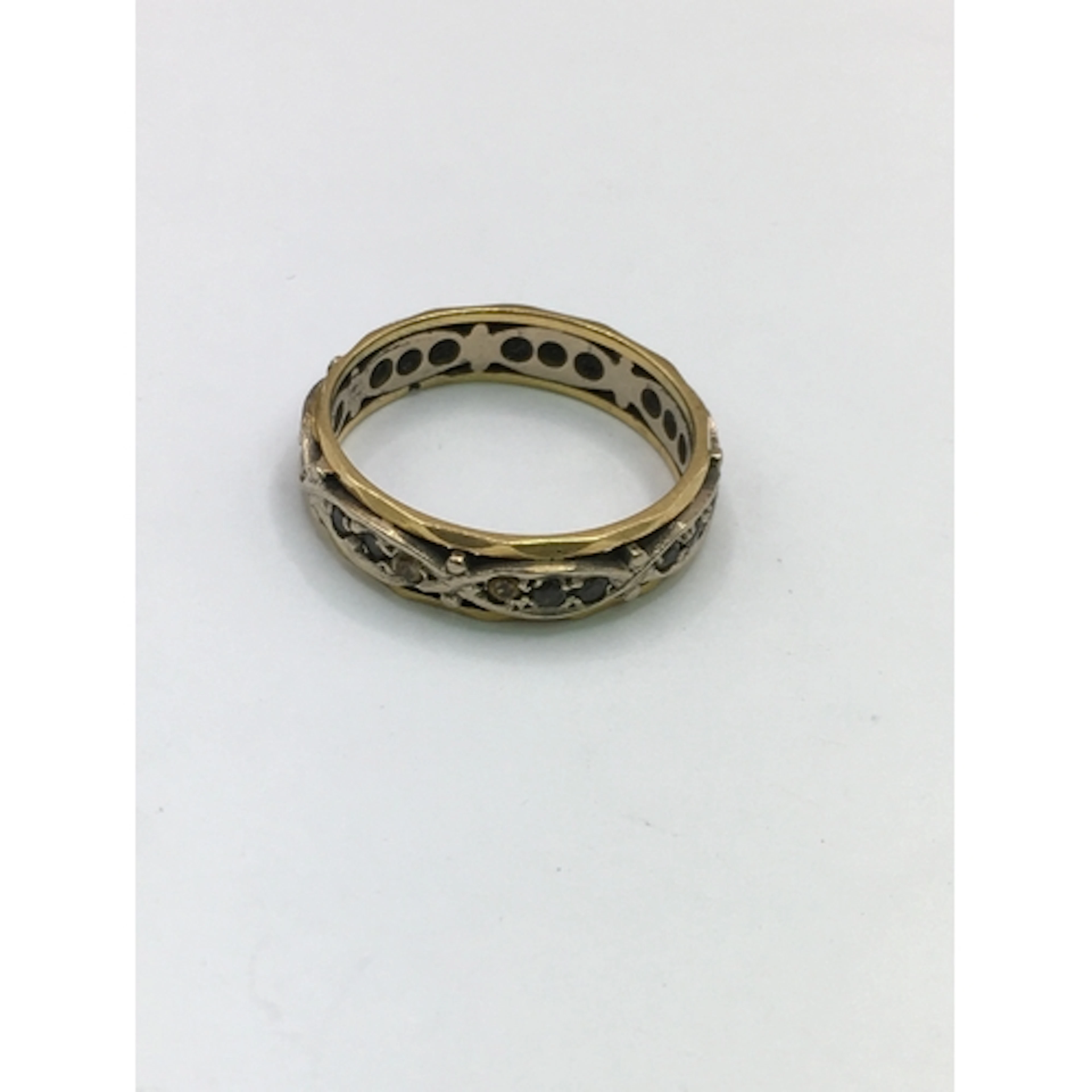 An unmarked yellow and white gold band ring set with small b...