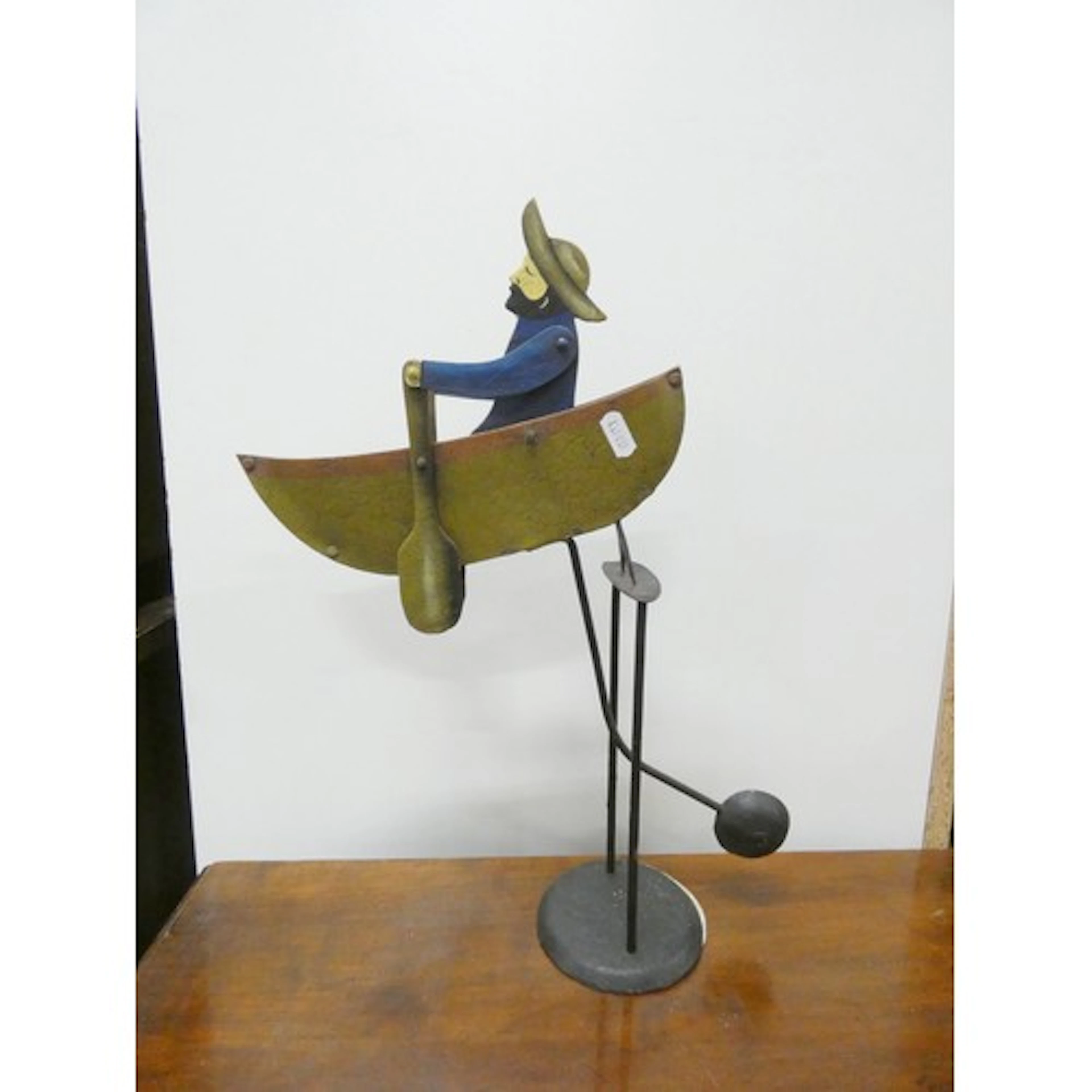Vintage tinplate swinging toy of a fisherman in a rowing boa...