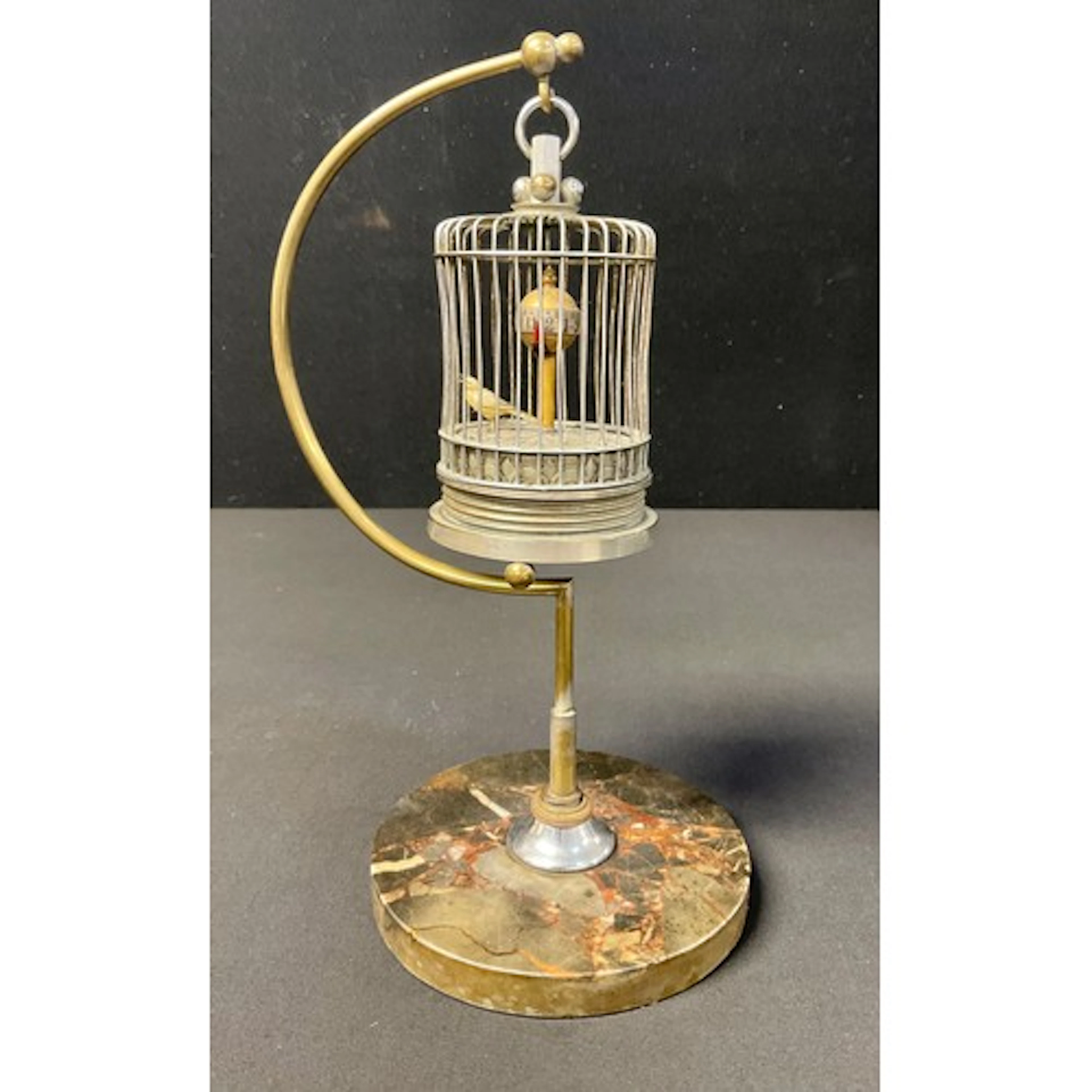 A novelty wind-up time piece in the form of a bird in a cage...