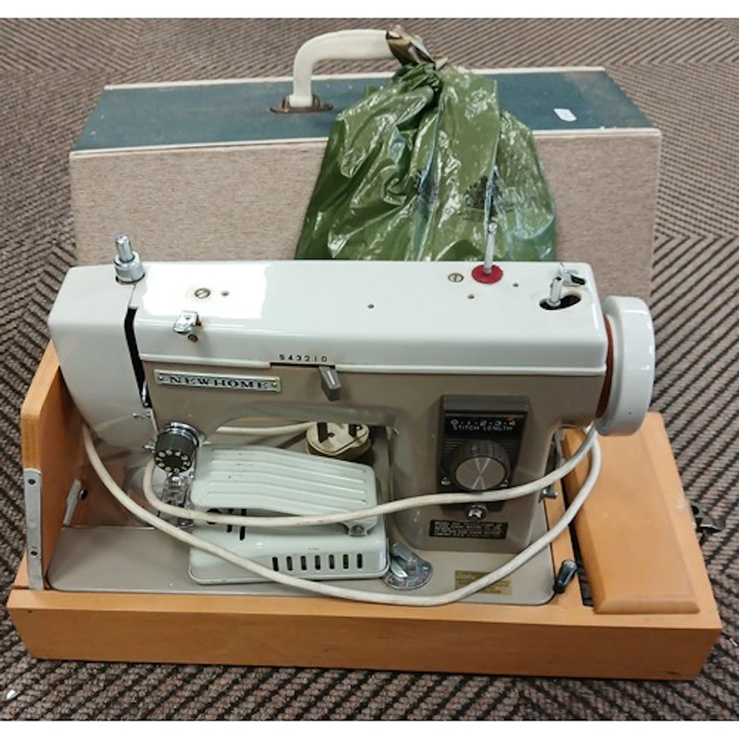 New Home sewing machine, cased with accessories.