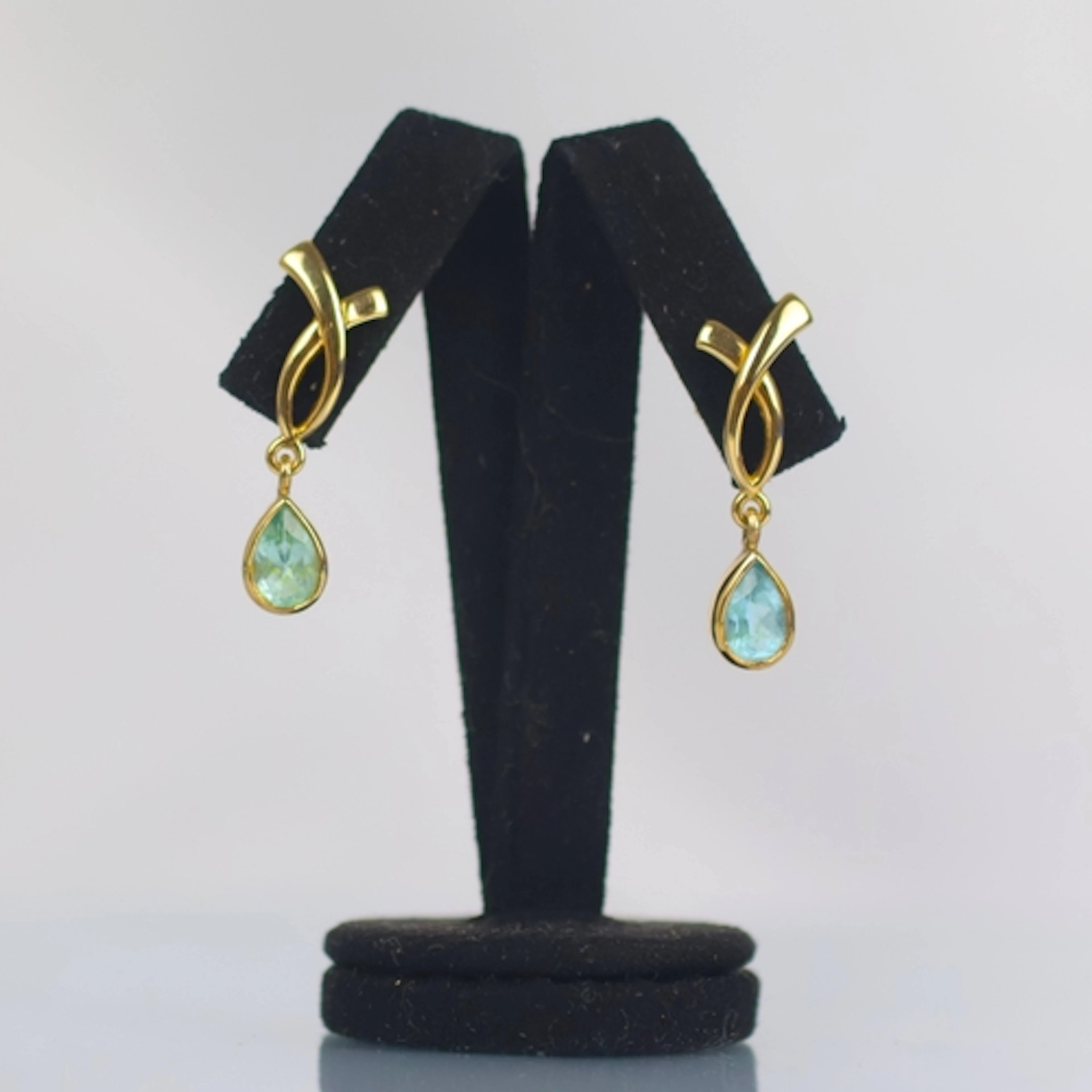 A pair of contemporary blue topaz set earrings, the pear cut...