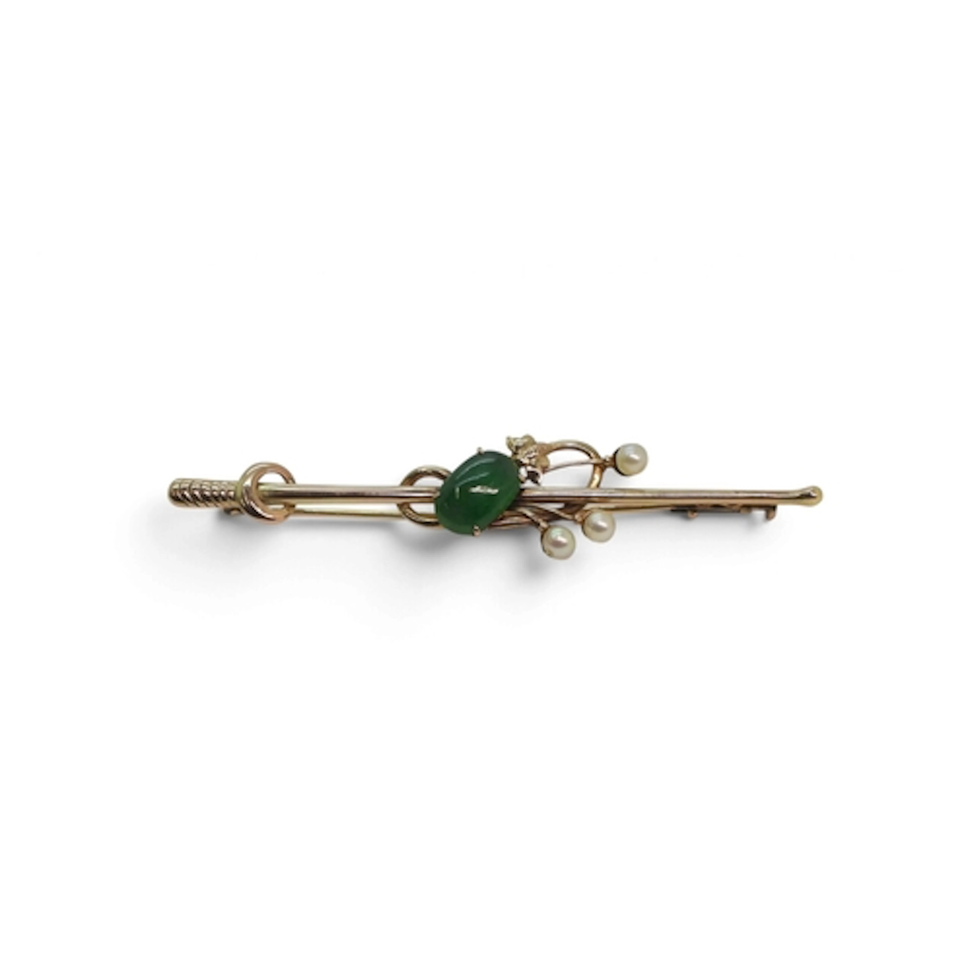 A yellow metal brooch set with a Chinese green hardstone and...