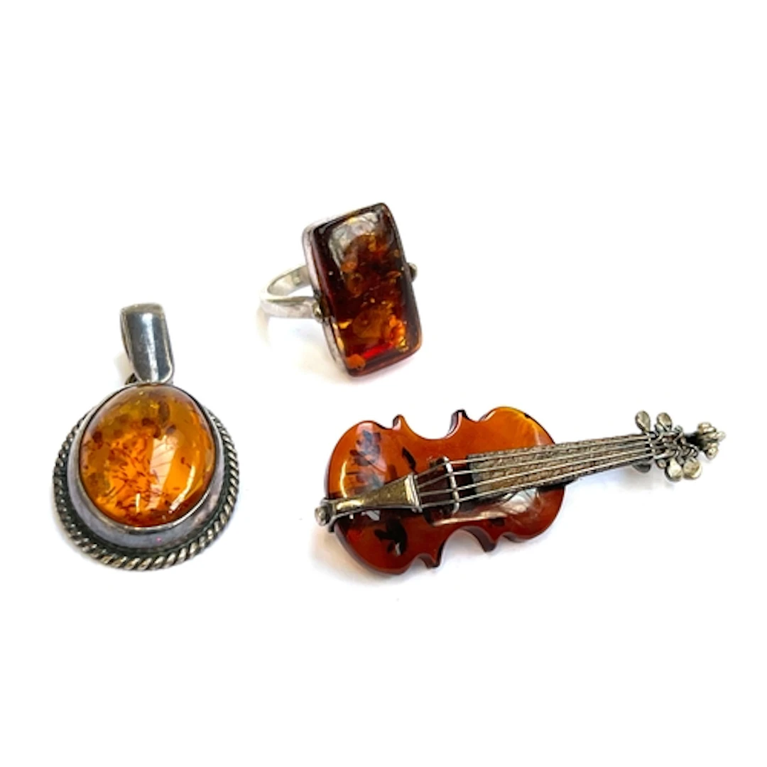 An amber and silver violin brooch, amber pendant, and amber ...