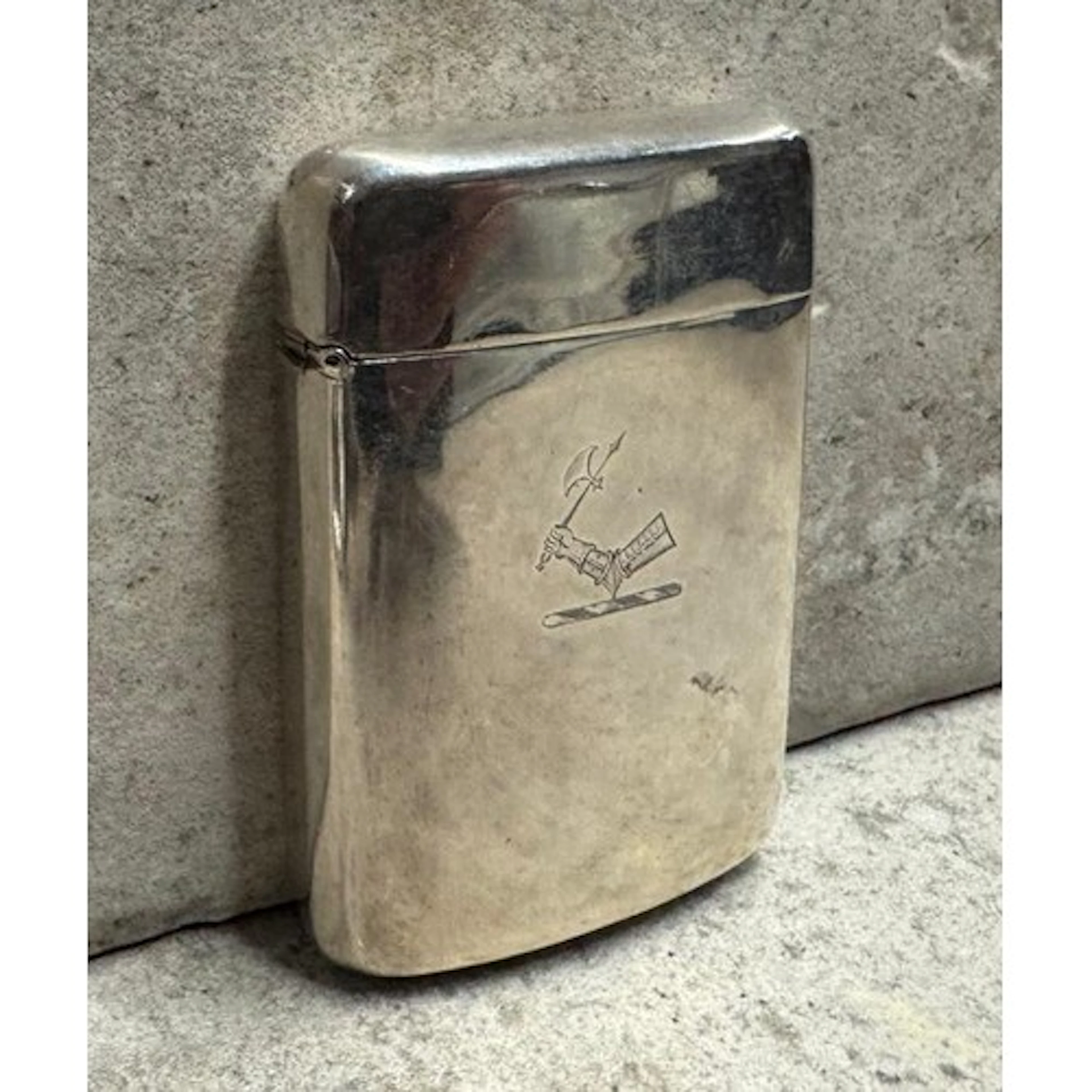 A silver card case with engraved Prince of Wales feathers de...