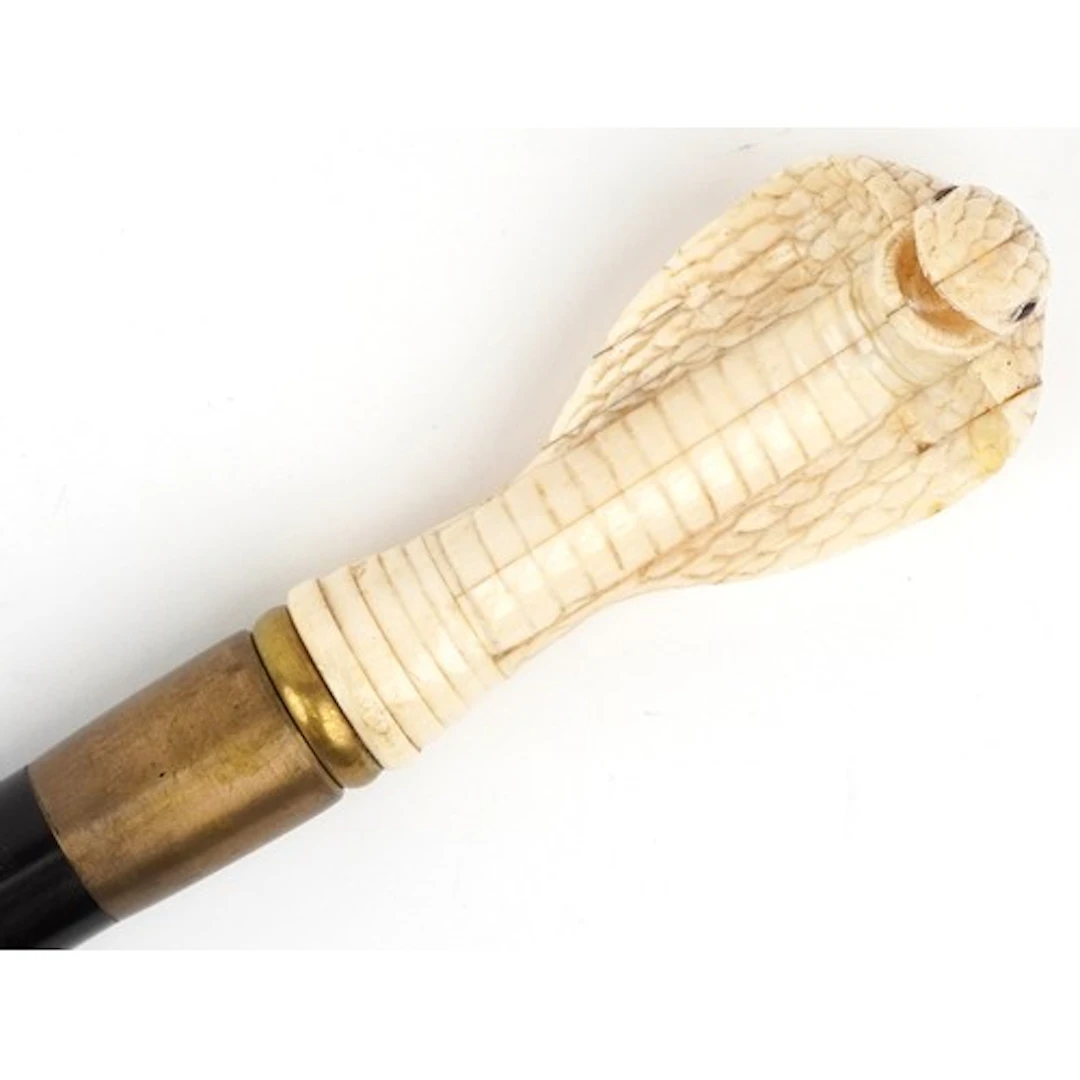 Hardwood walking stick with bone handle in the form of a cob...