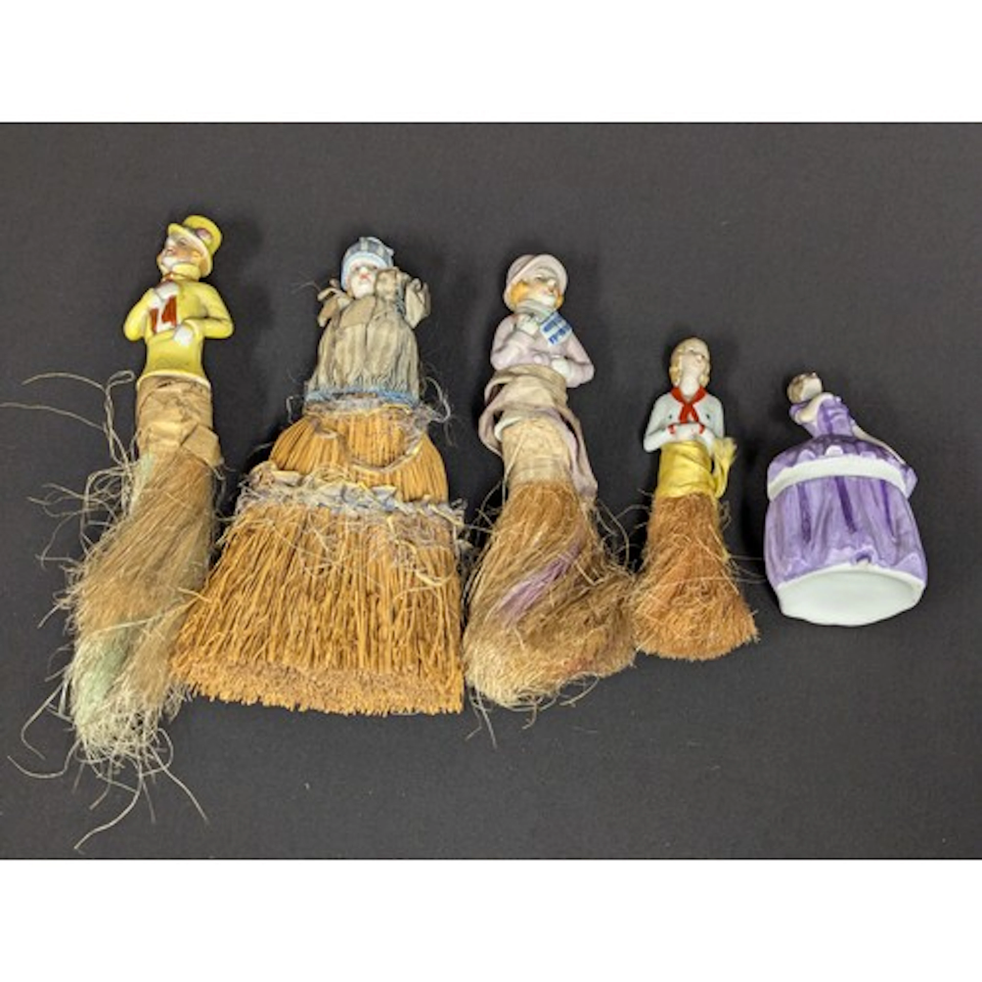 A collection of four half porcelain doll brushes, painted as...