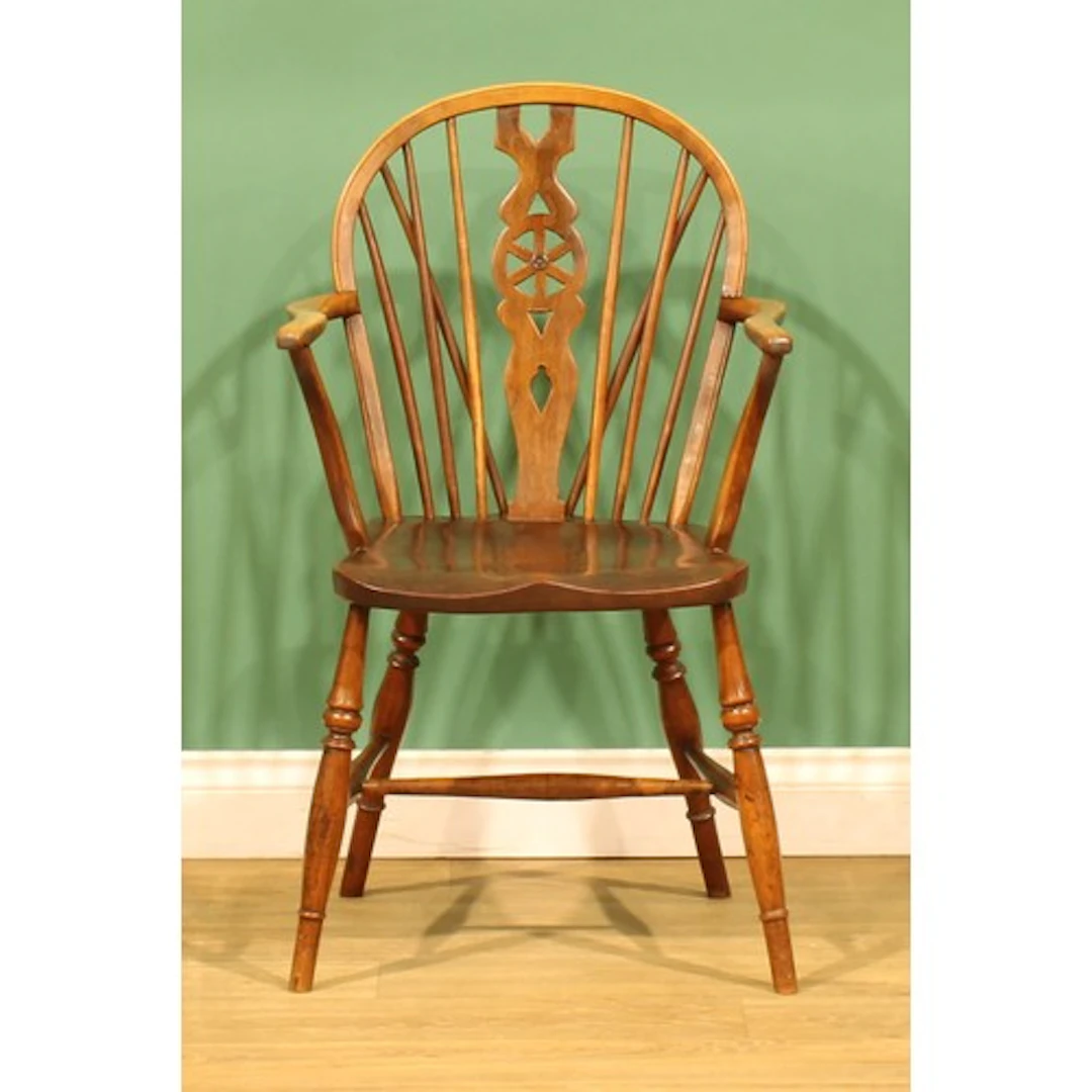 A 19th century fruitwood wheelback Windsor elbow chair, 88cm...