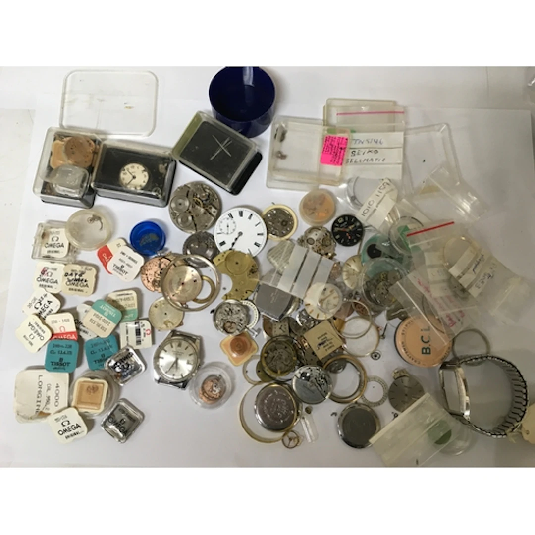 A bag of assorted watch parts including Omega